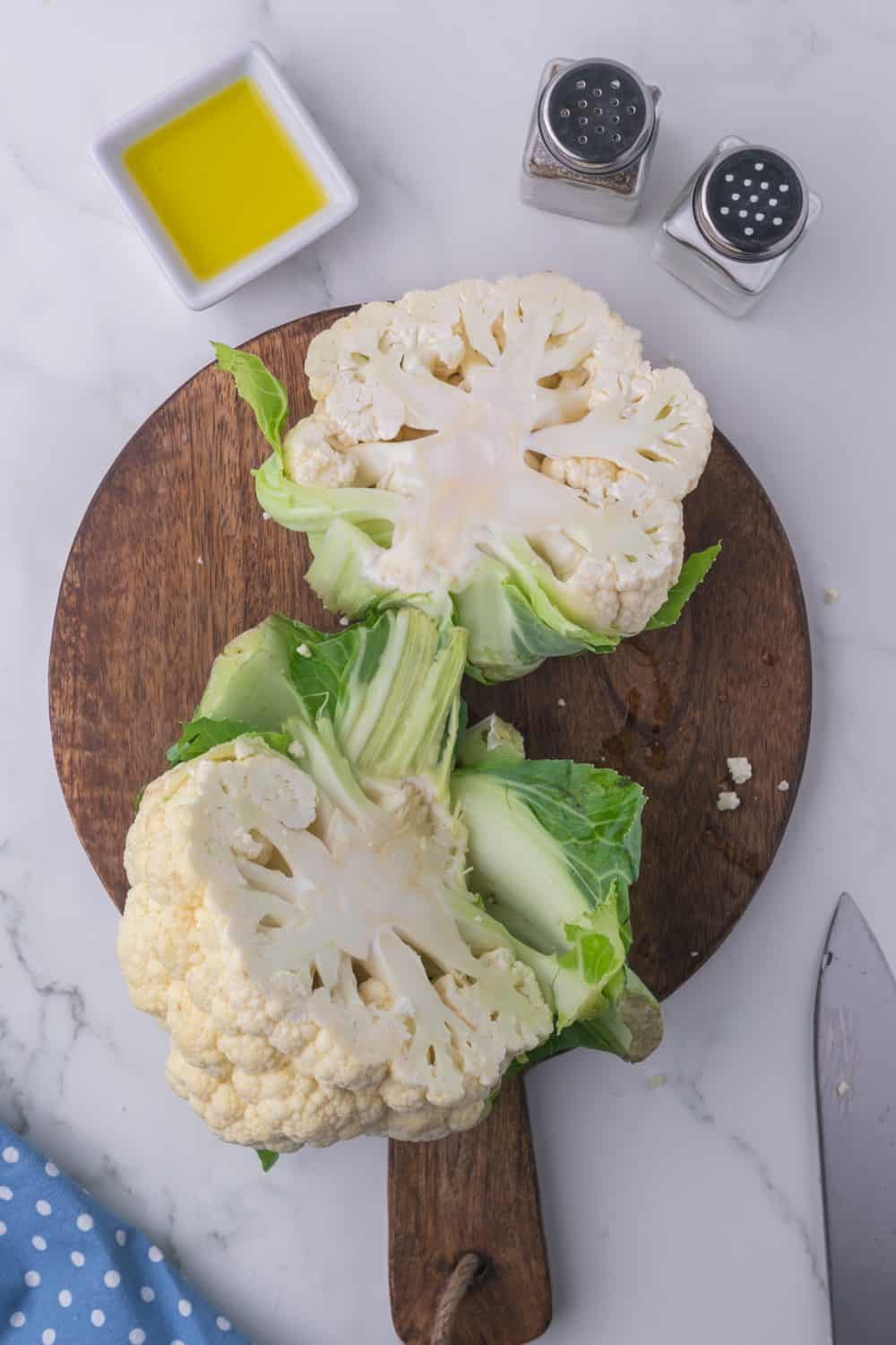 whole cauliflower on a wooden board cut in half