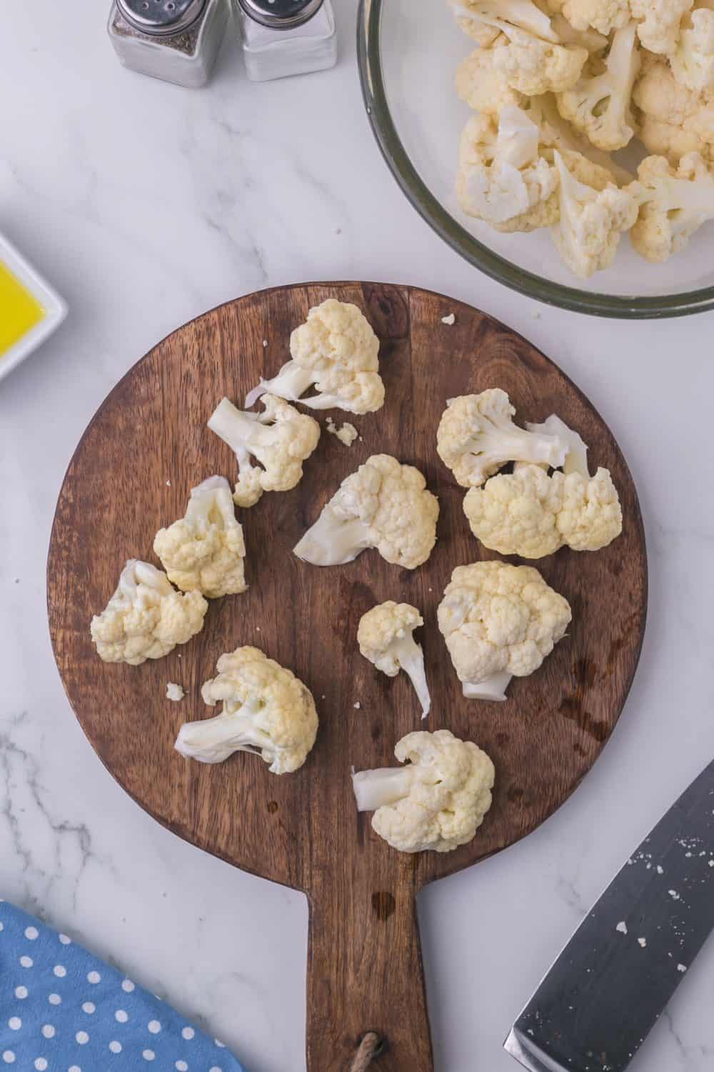 round wooden chopping block with diced cauliflower