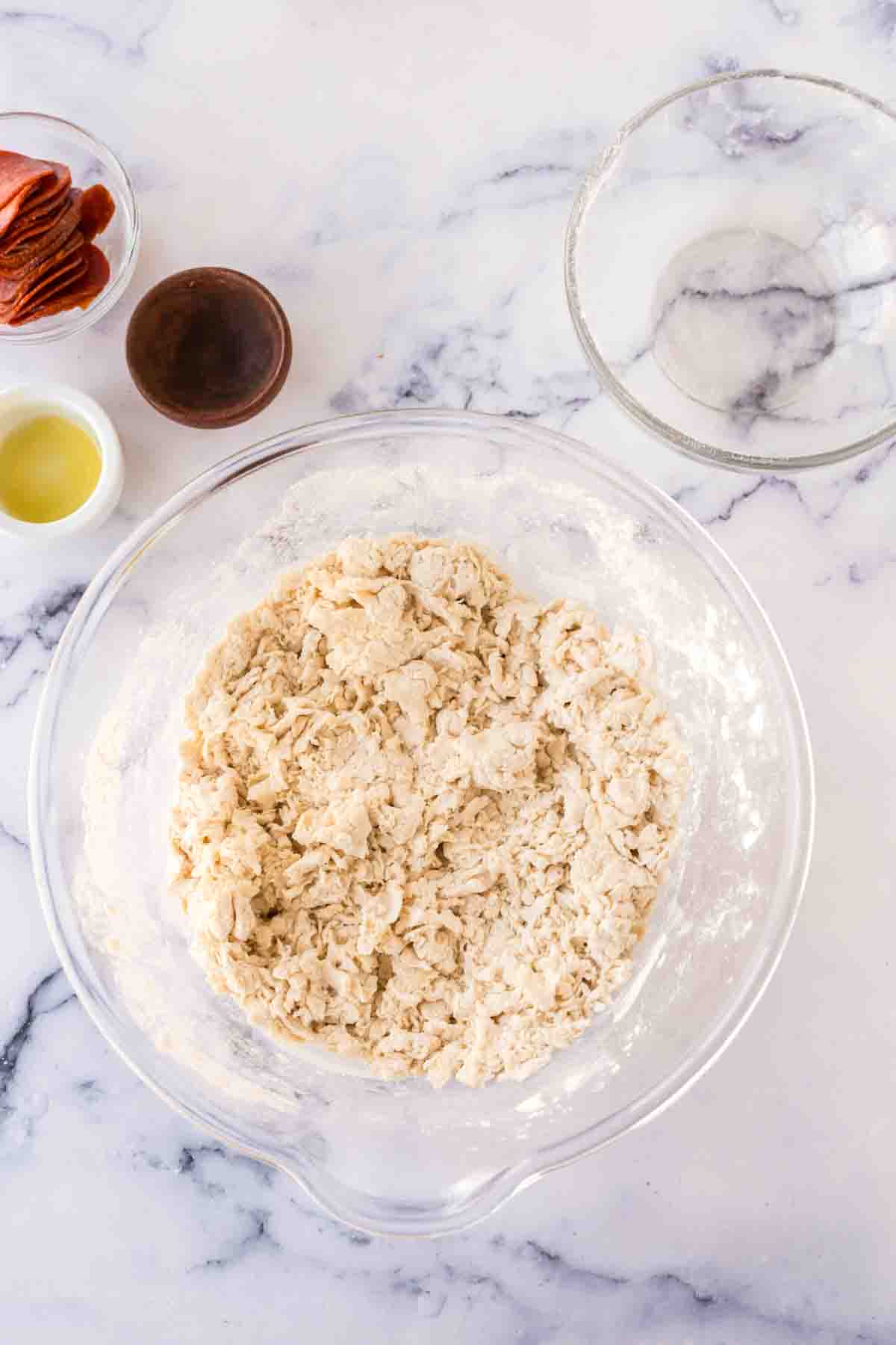 stuff crust pizza dough in a clear mixing bowl