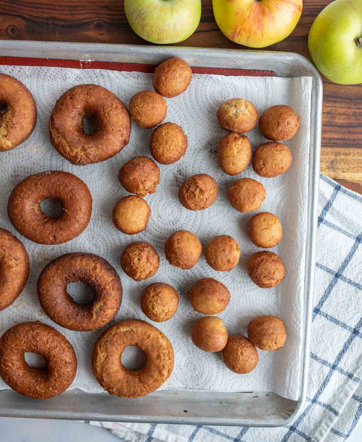 un-sugared apple cider donuts on a paper towel.