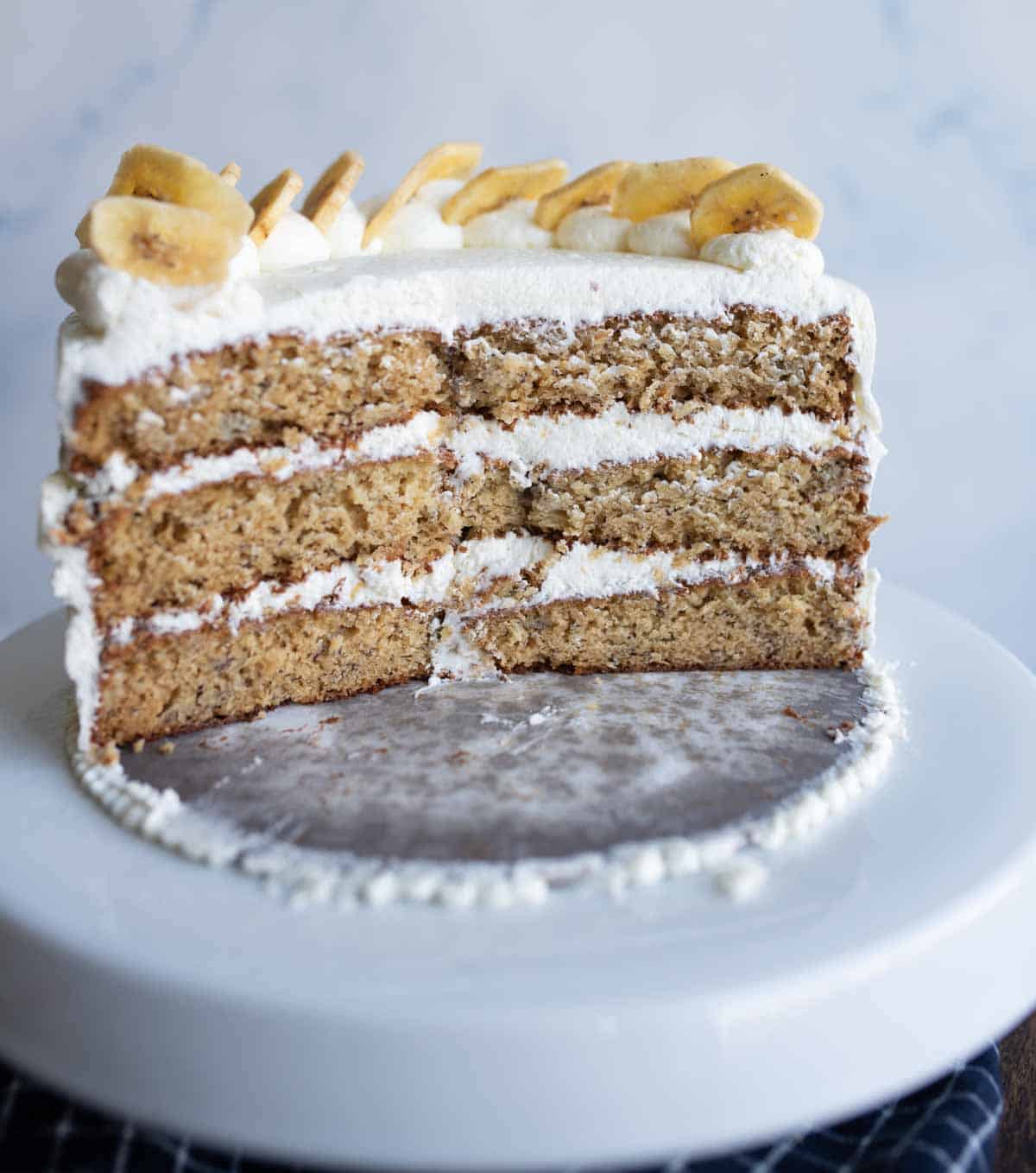 half cut three layer banana cake with white frosting