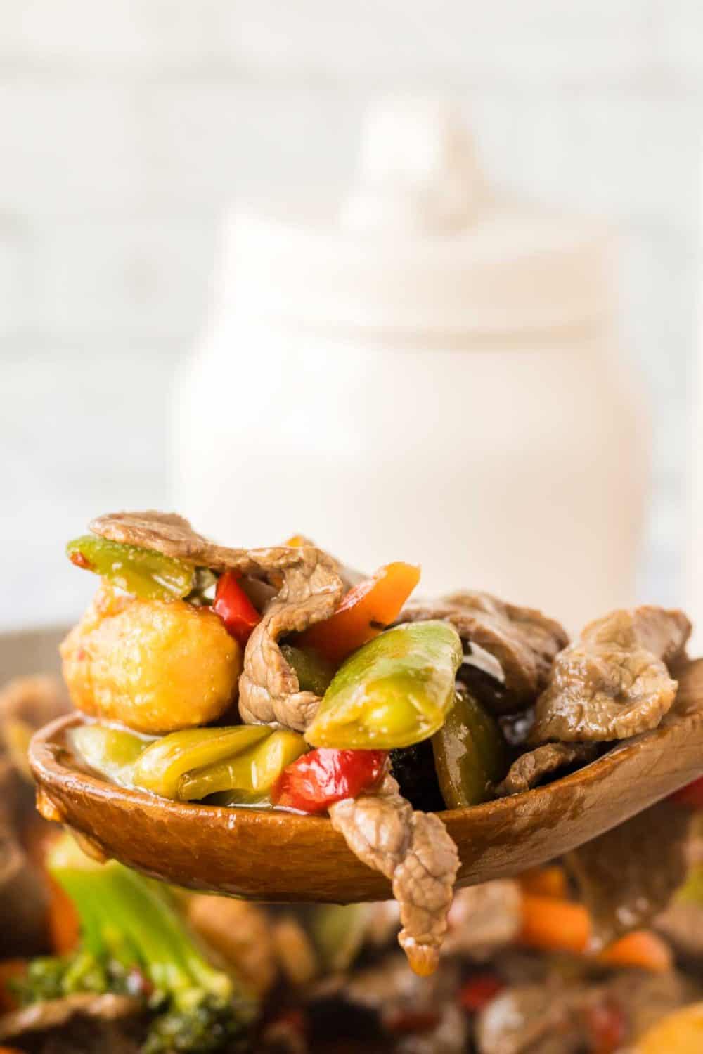side view POV of a wooden spoon with hunan beef