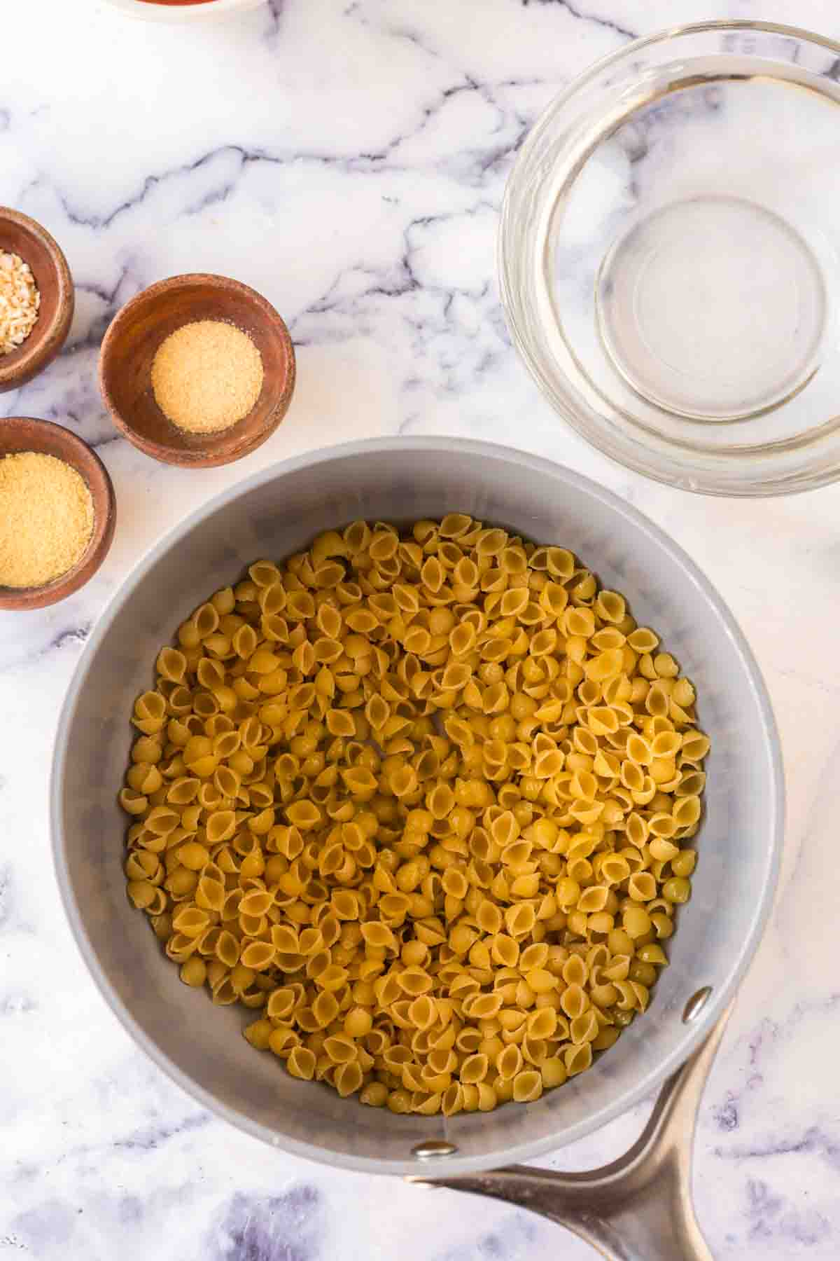 sauce pan with raw pasta for sopitas ingredients.