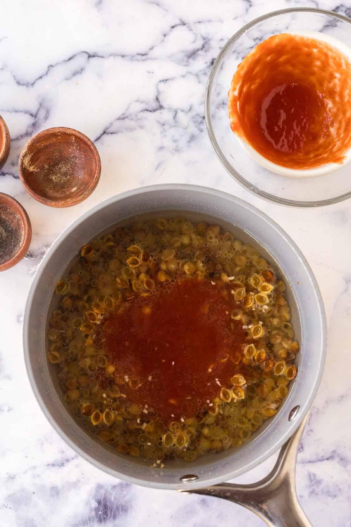 sauce pan with raw pasta for sopitas ingredients.