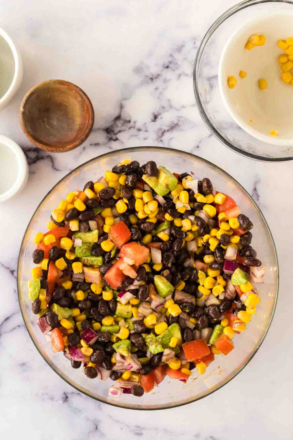 ingredients for texas caviar in a clear mixing bowl
