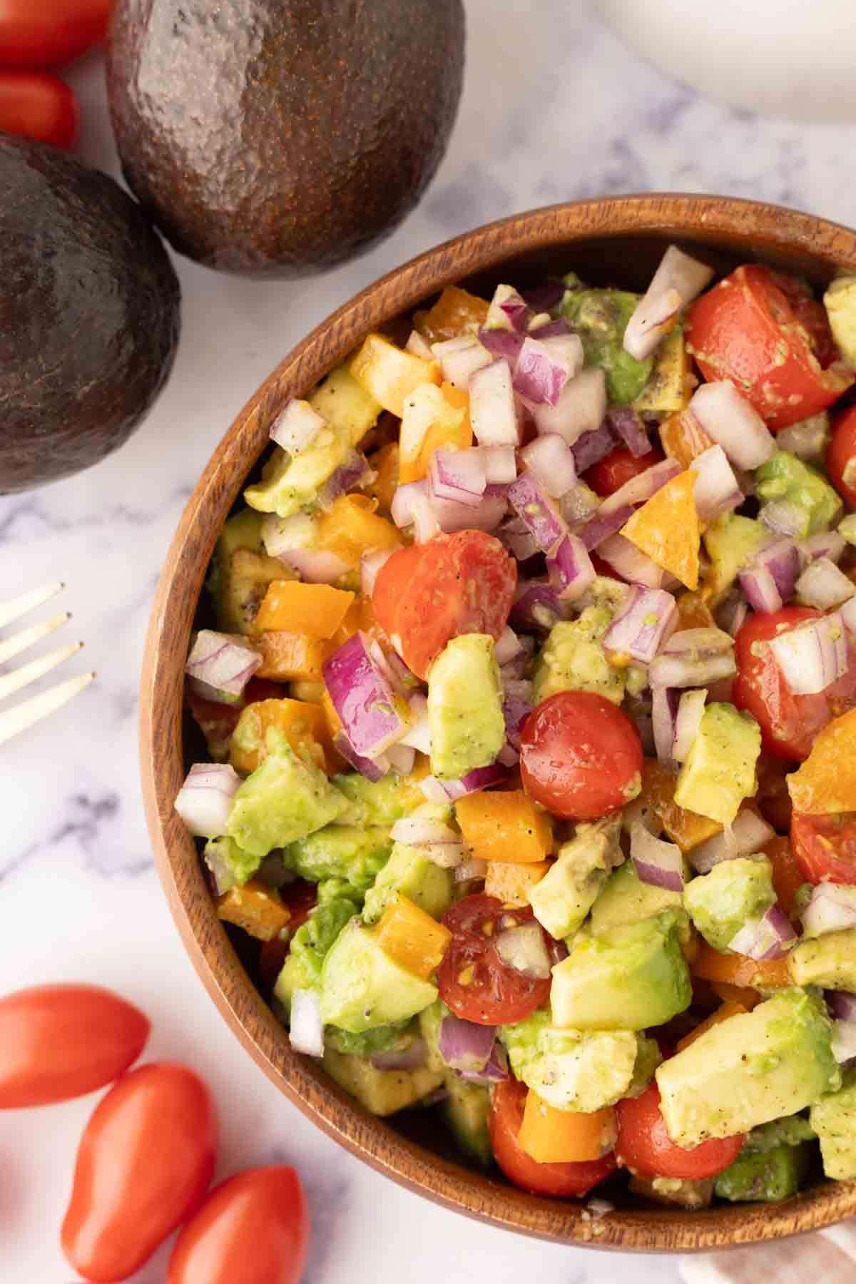 top view close up of avocado salad recipe in a wooden bowl