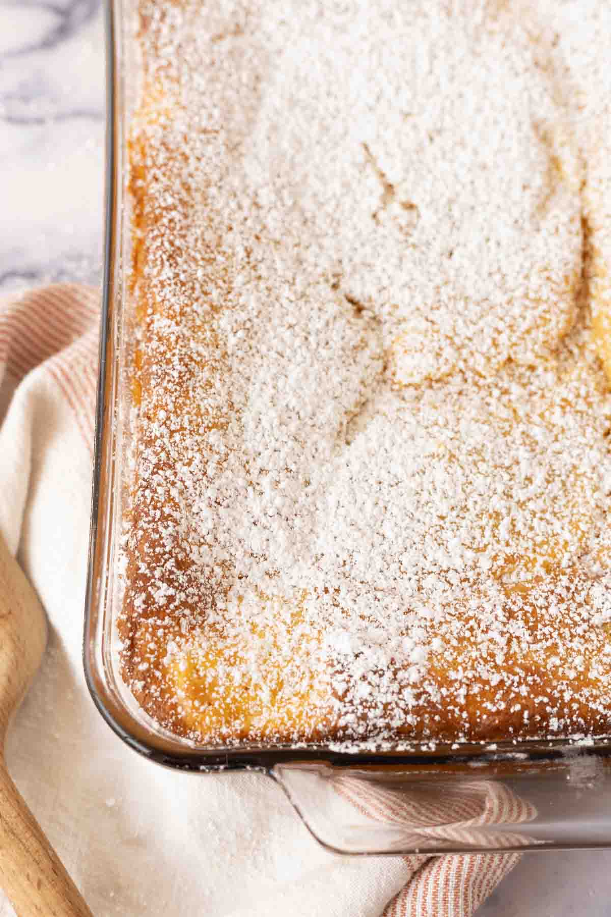 ugly cake recipe baked in the dish and dusted with powdered sugar