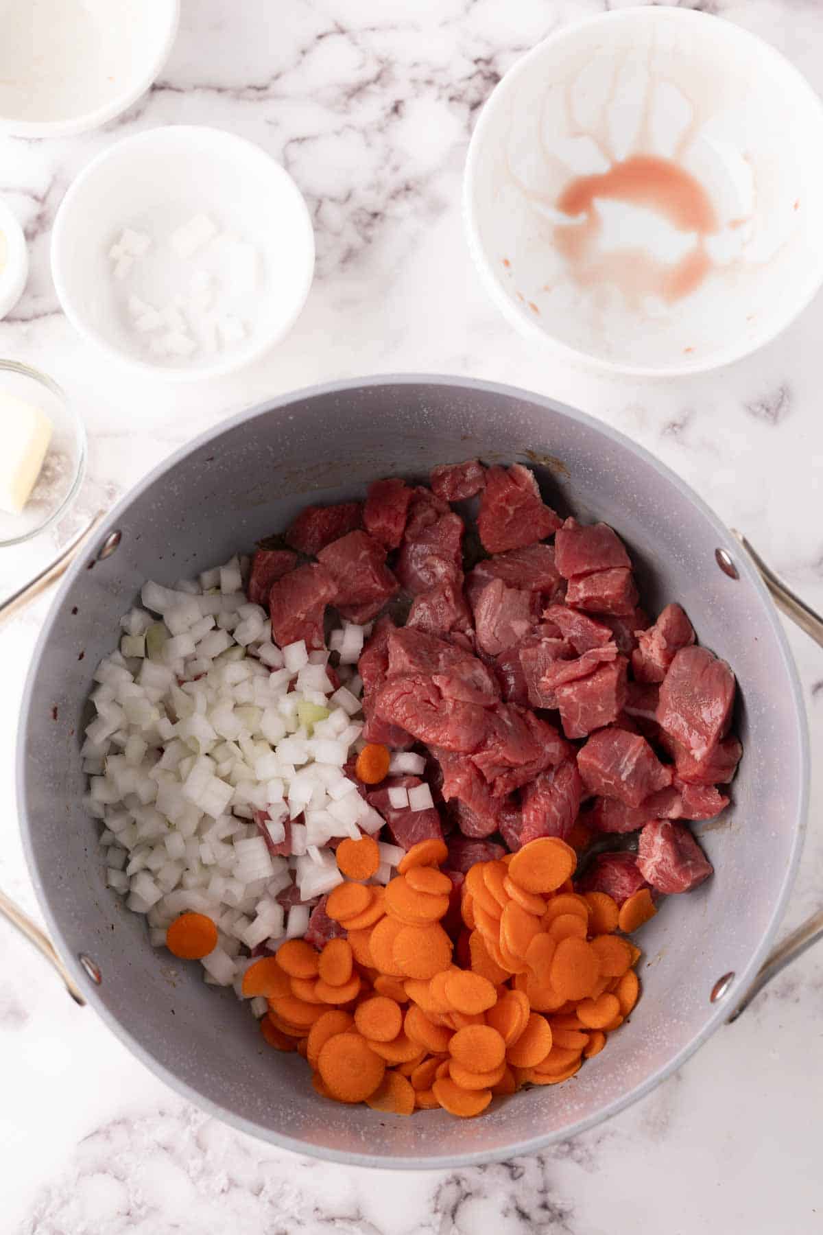pan with raw ingredients for Beef Bourguignon Recipe in progress.