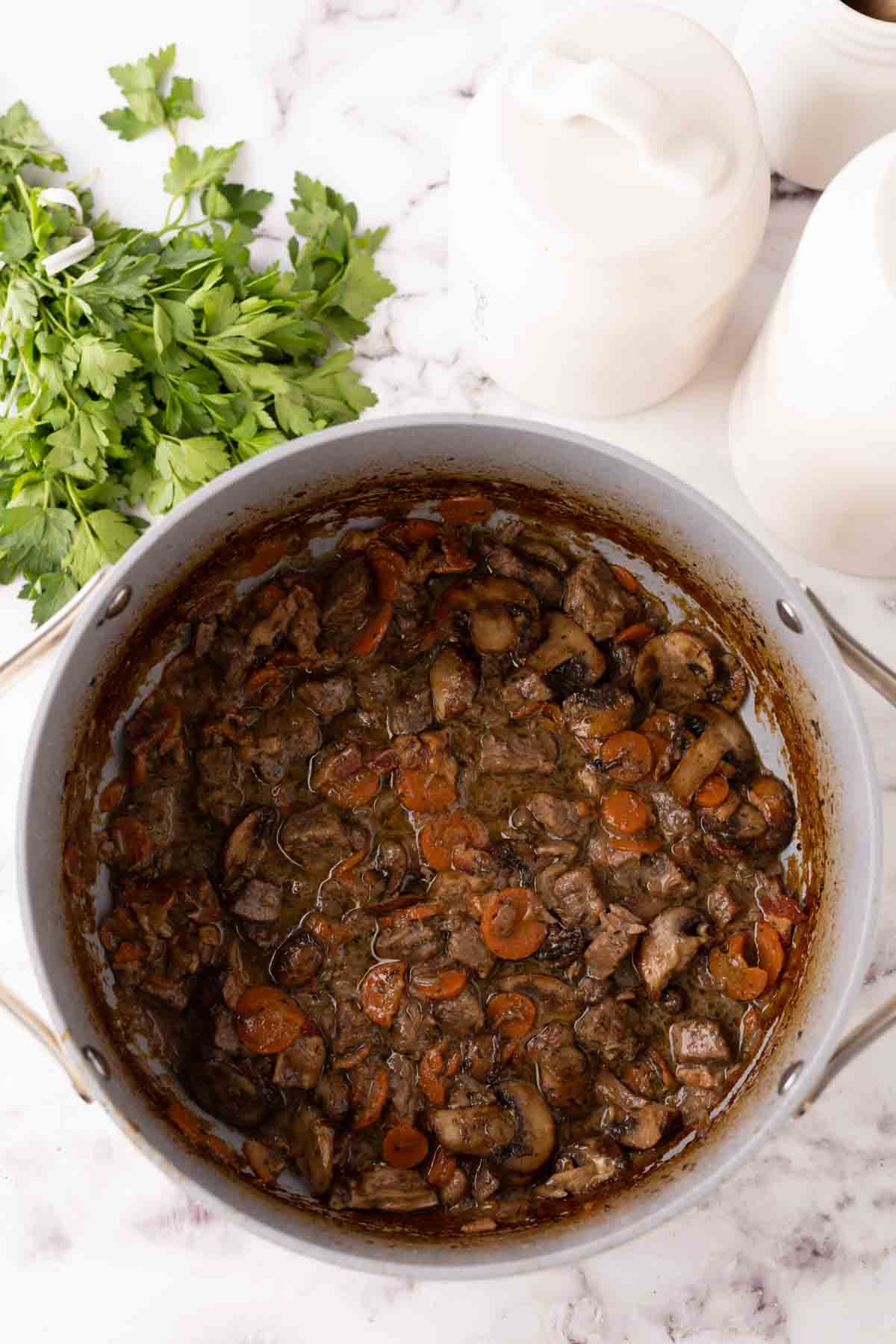 pan with raw ingredients for Beef Bourguignon Recipe in progress.