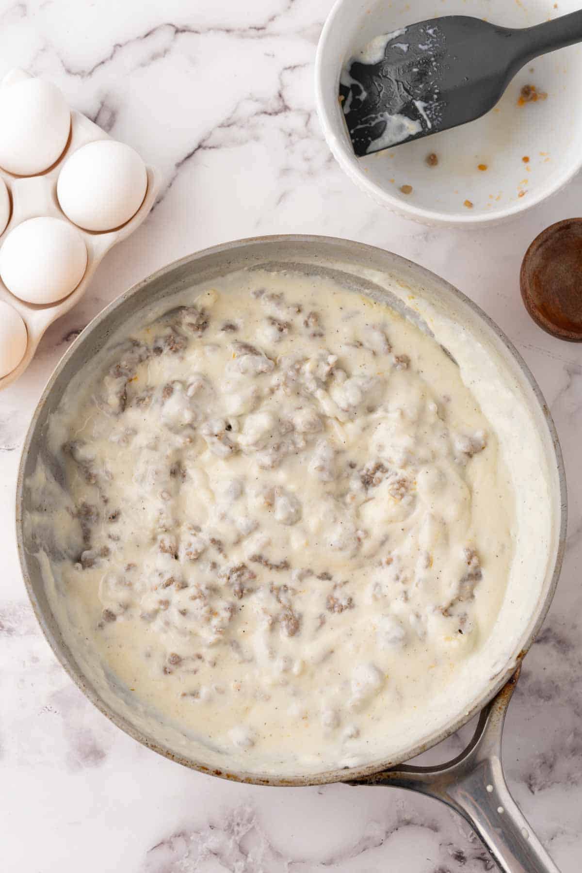 pot with the progress of making biscuits and gravy.