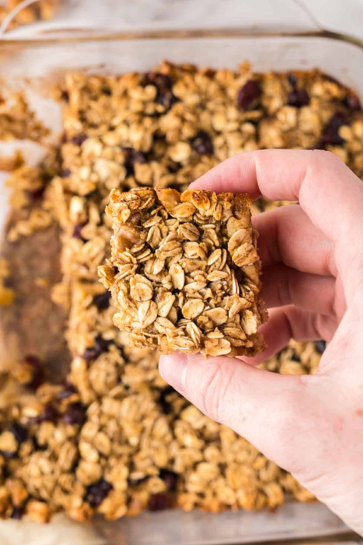 POV holding a square portion serving of breakfast bars.