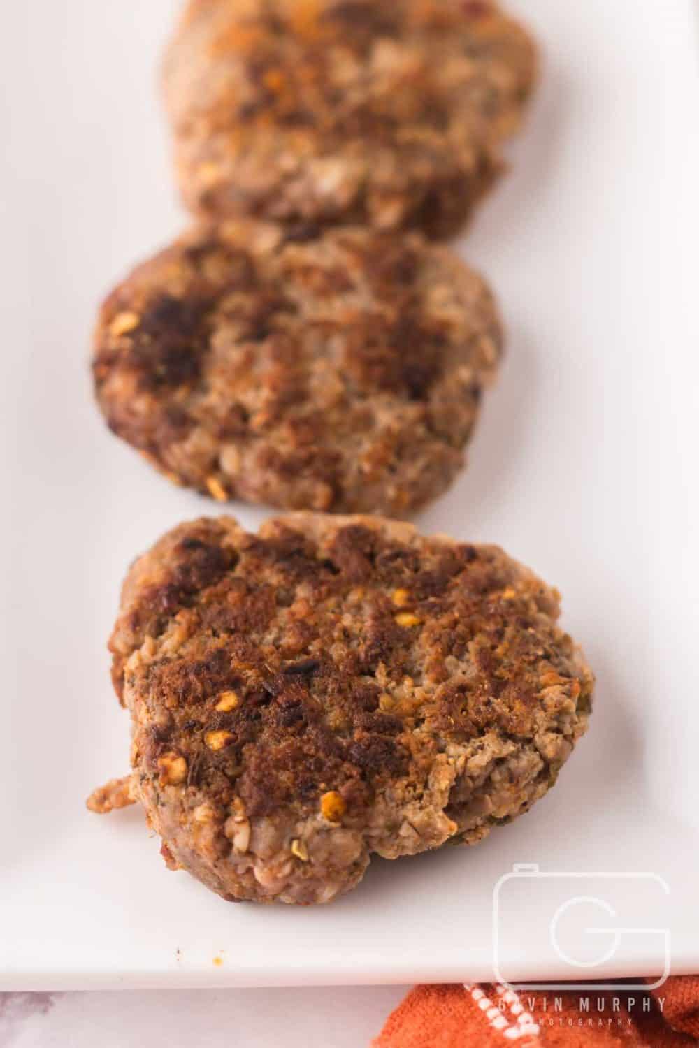 breakfast sausages in a row on a plate.