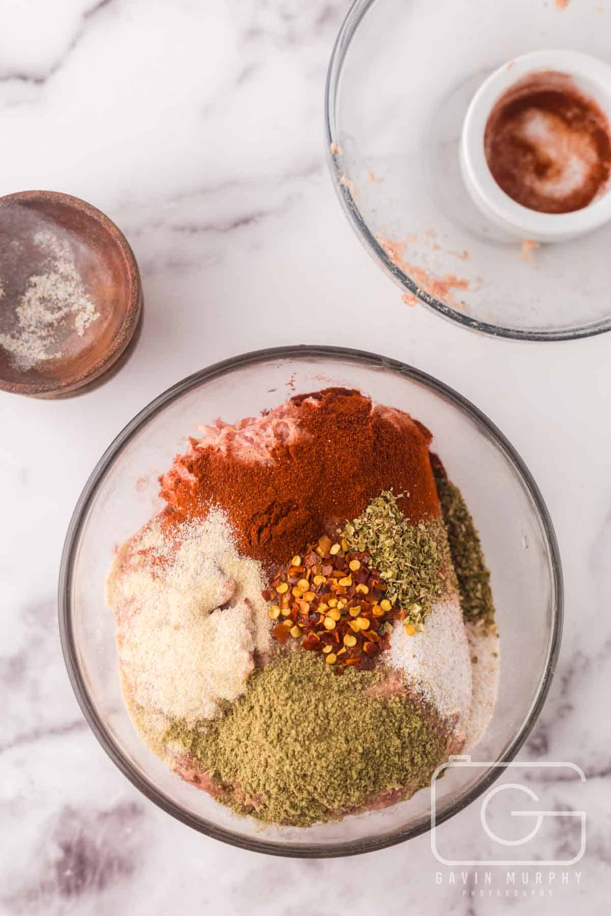 clear mixing bowl with sausage and seasonings.