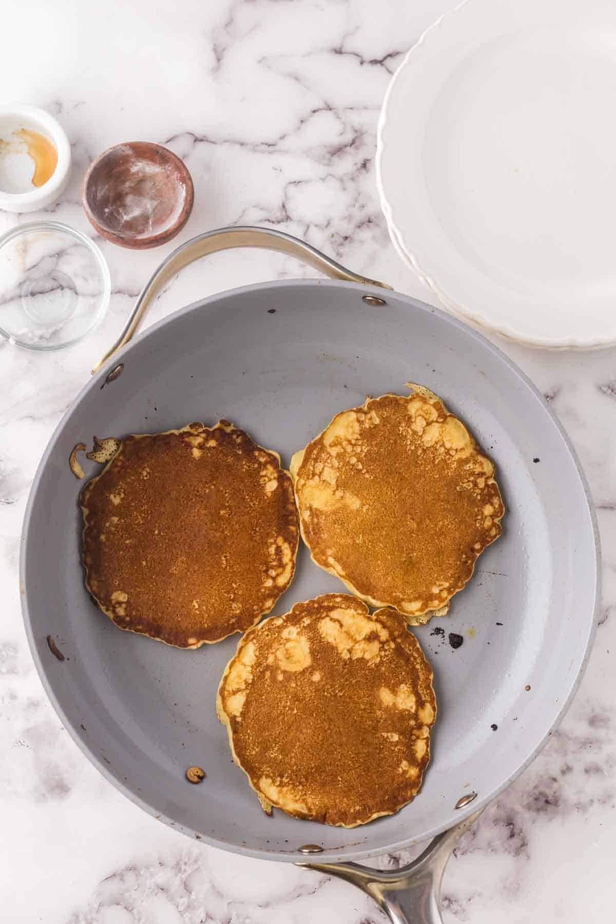 pan with three buttermilk pancakes.