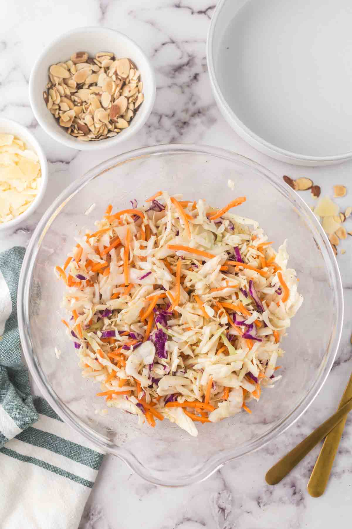 clear mixing bowl with the progress of making cabbage salad.
