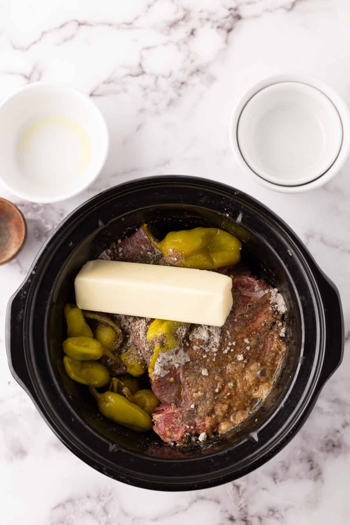 tender Mississippi shredded pot roast ingredients inside a slow cooker machine.