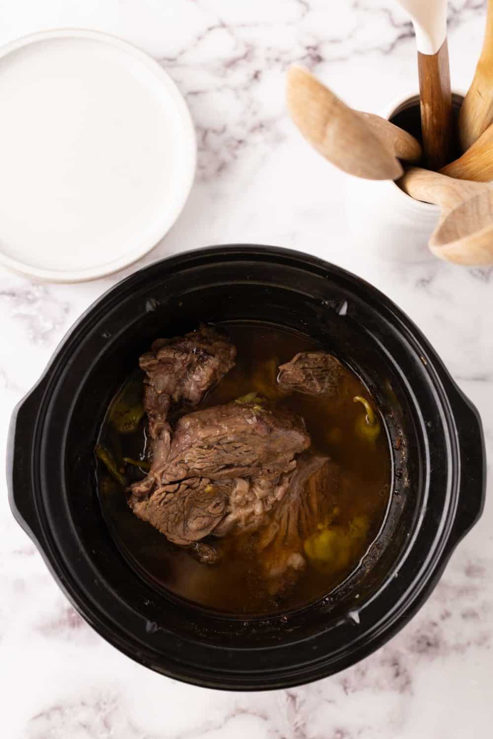 tender Mississippi shredded pot roast inside a slow cooker.