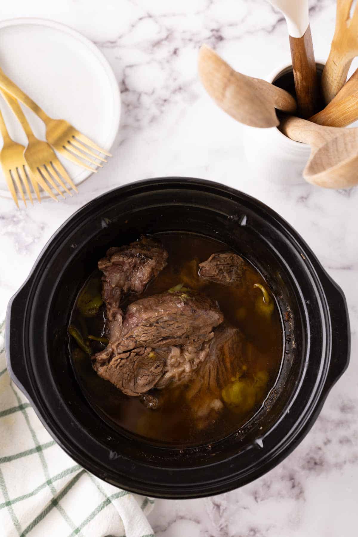 tender Mississippi shredded pot roast inside a slow cooker.