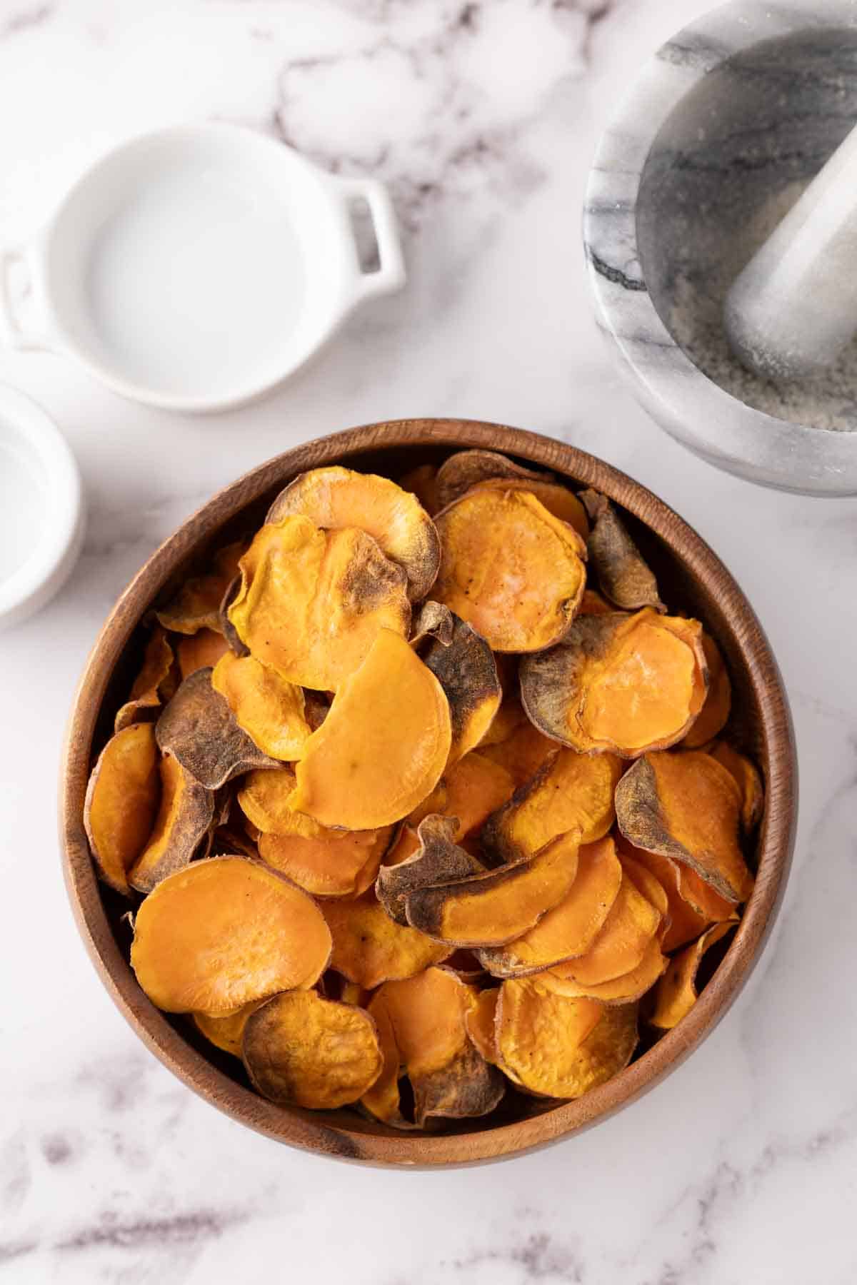 wooden bowl with air fried sweet potato chips.