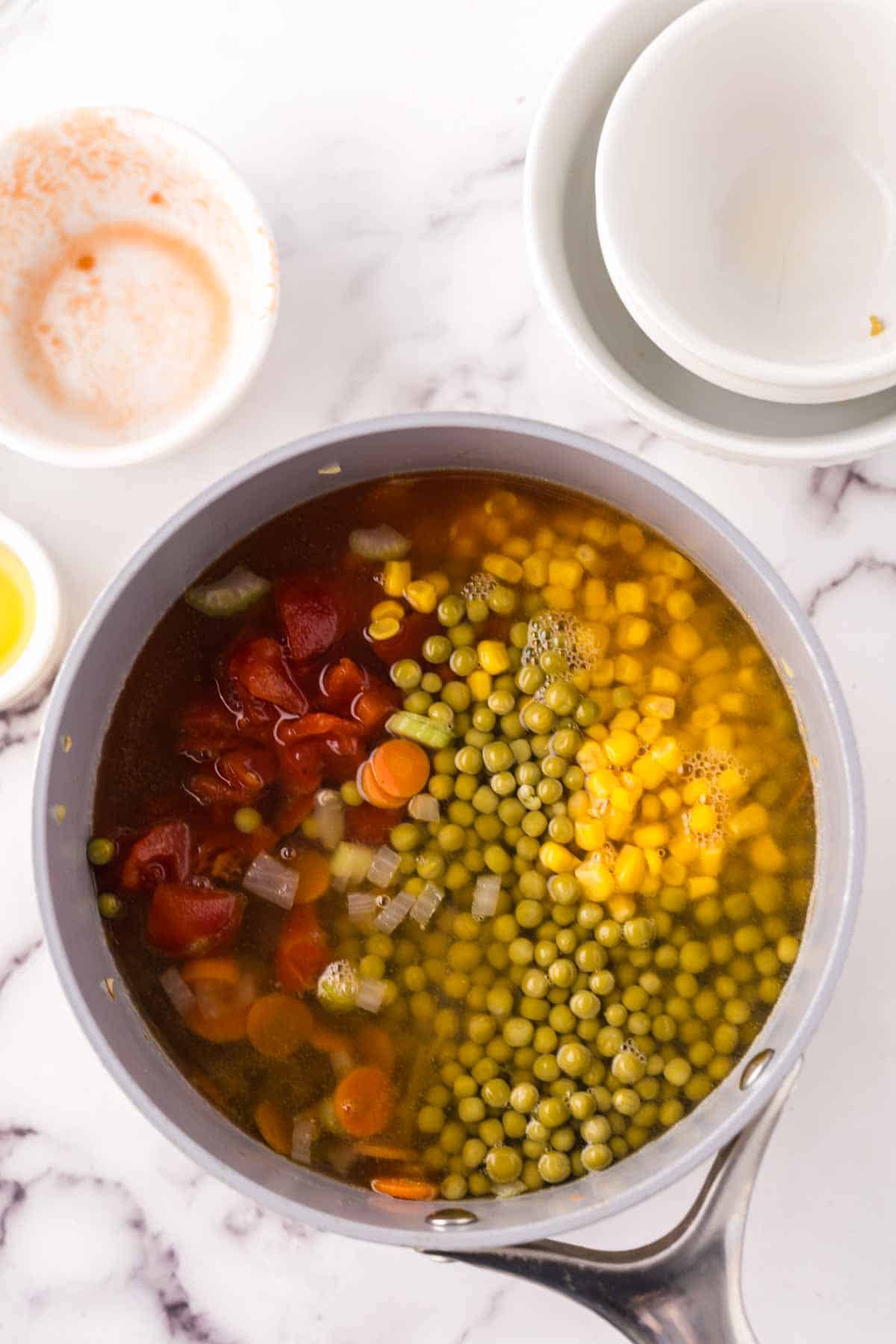 Combining ingredients in a pot for vegetable soup.