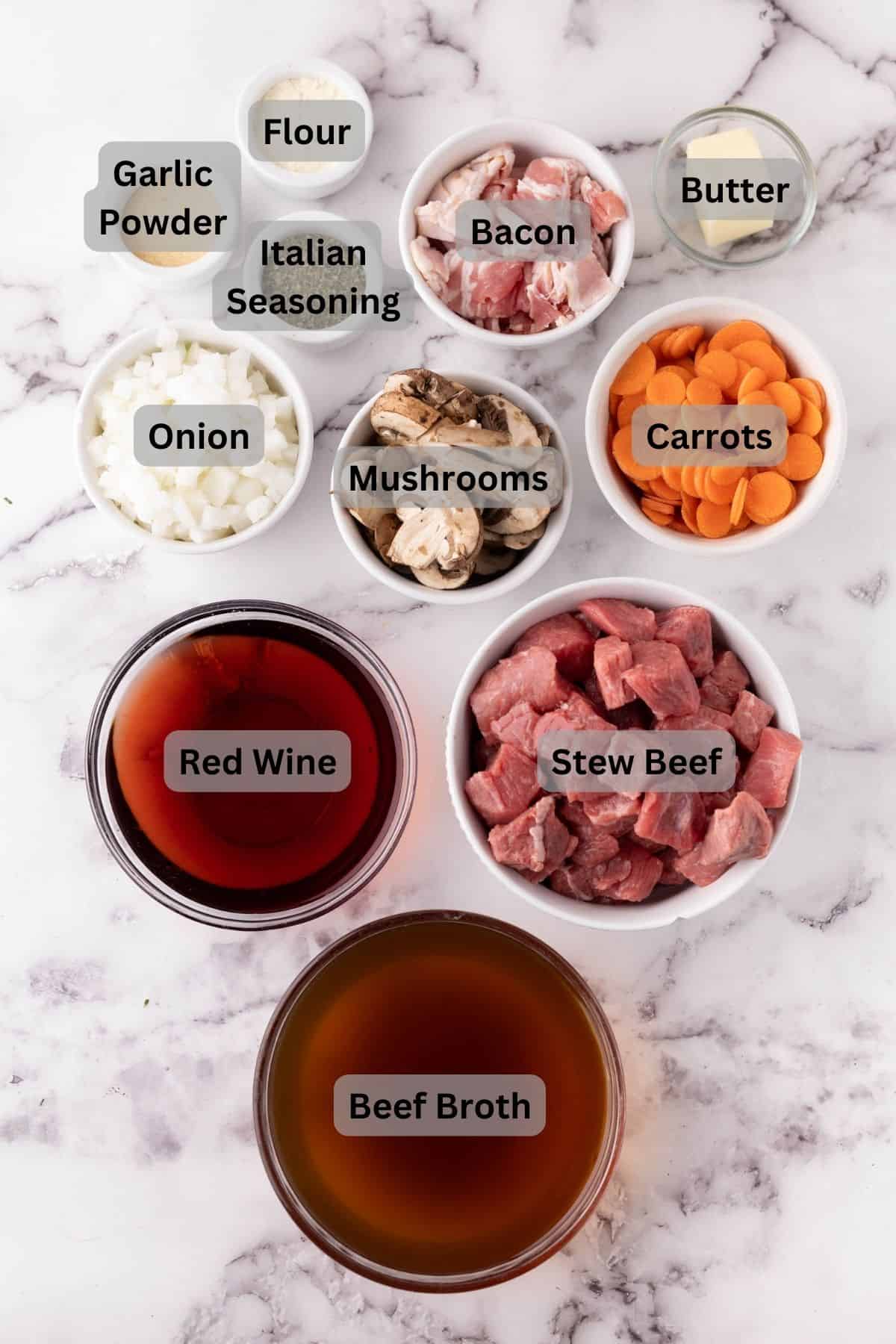 Ingredients for beef bourguignon portioned out in bowls and digitally labeled.