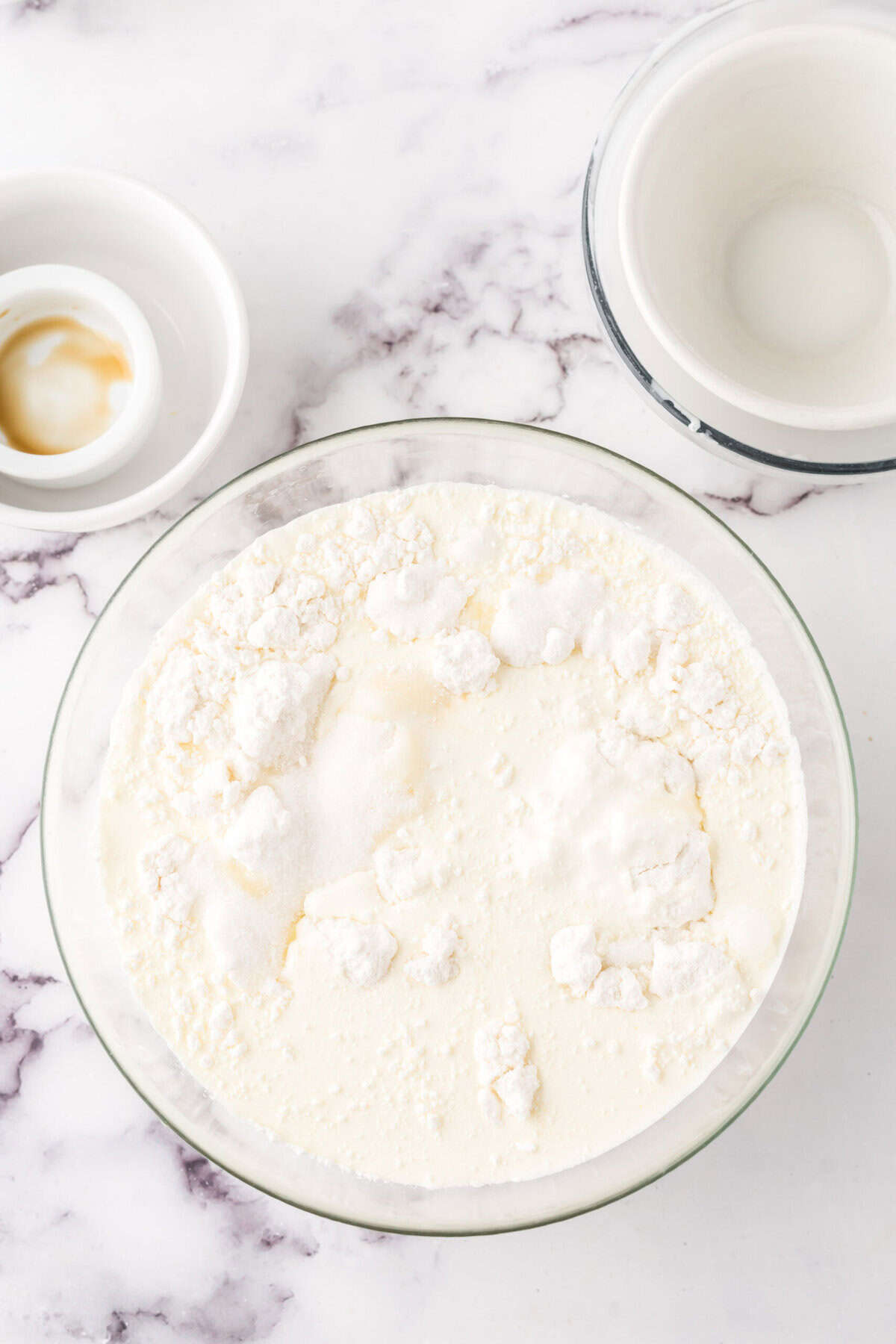 clear mixing bowl in the process of making cake batter ice cream.