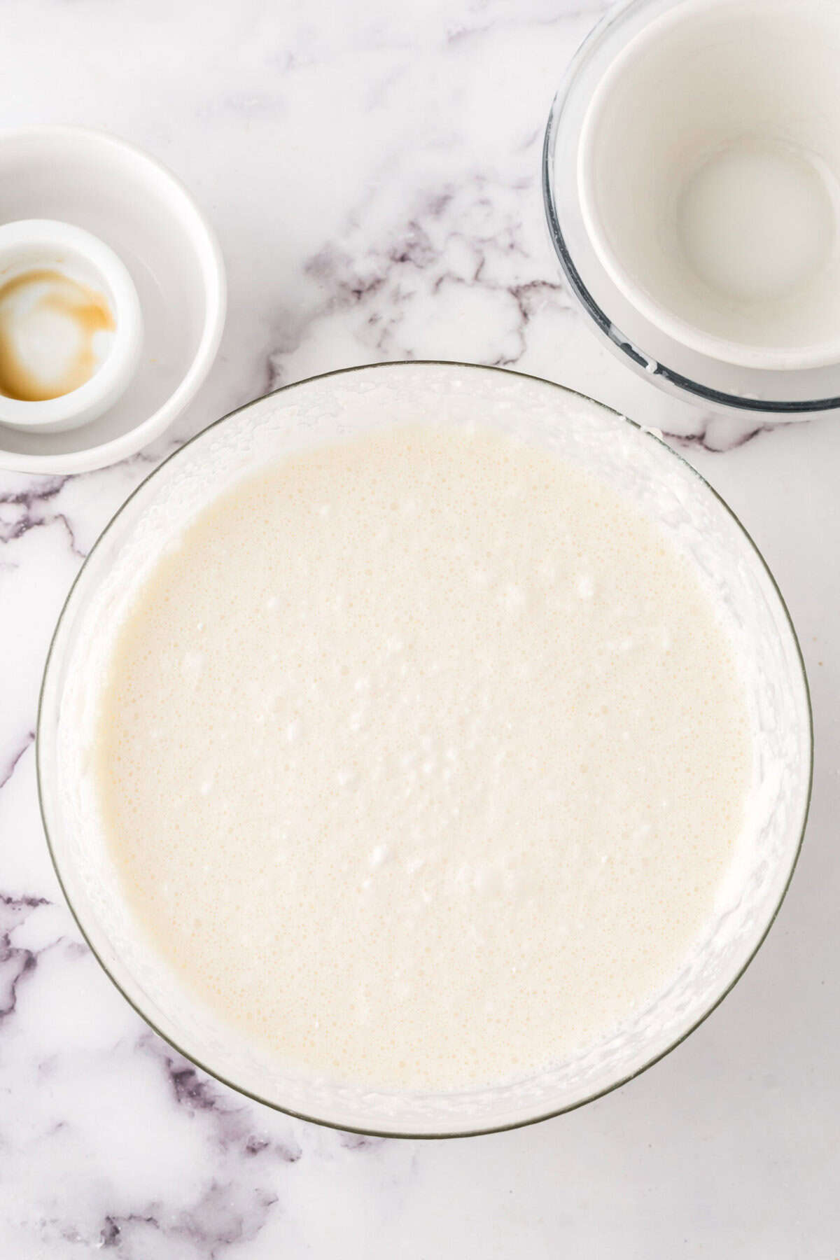 clear mixing bowl in the process of making cake batter ice cream.