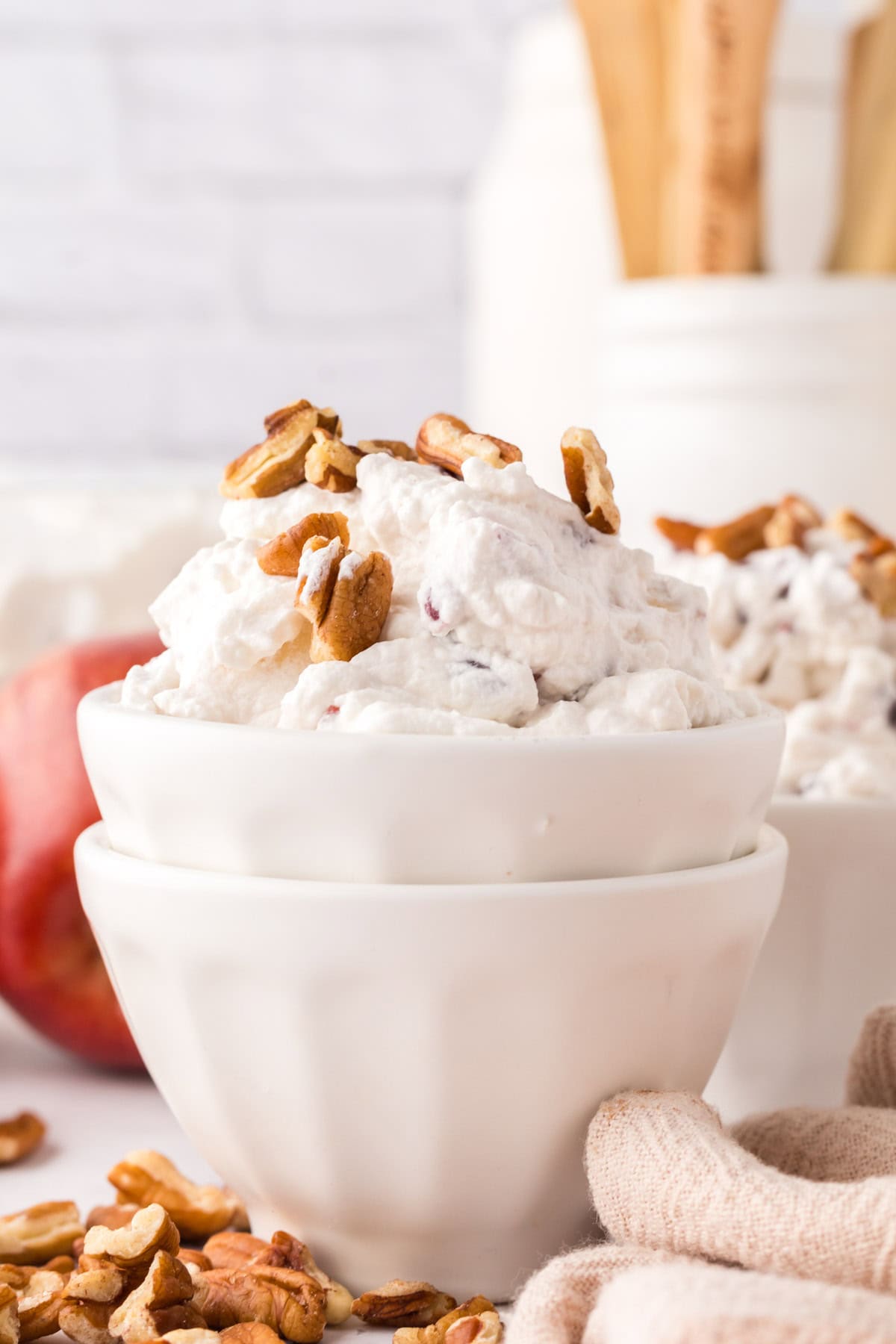 small white portion bowl with dixie salad recipe and walnuts on top.