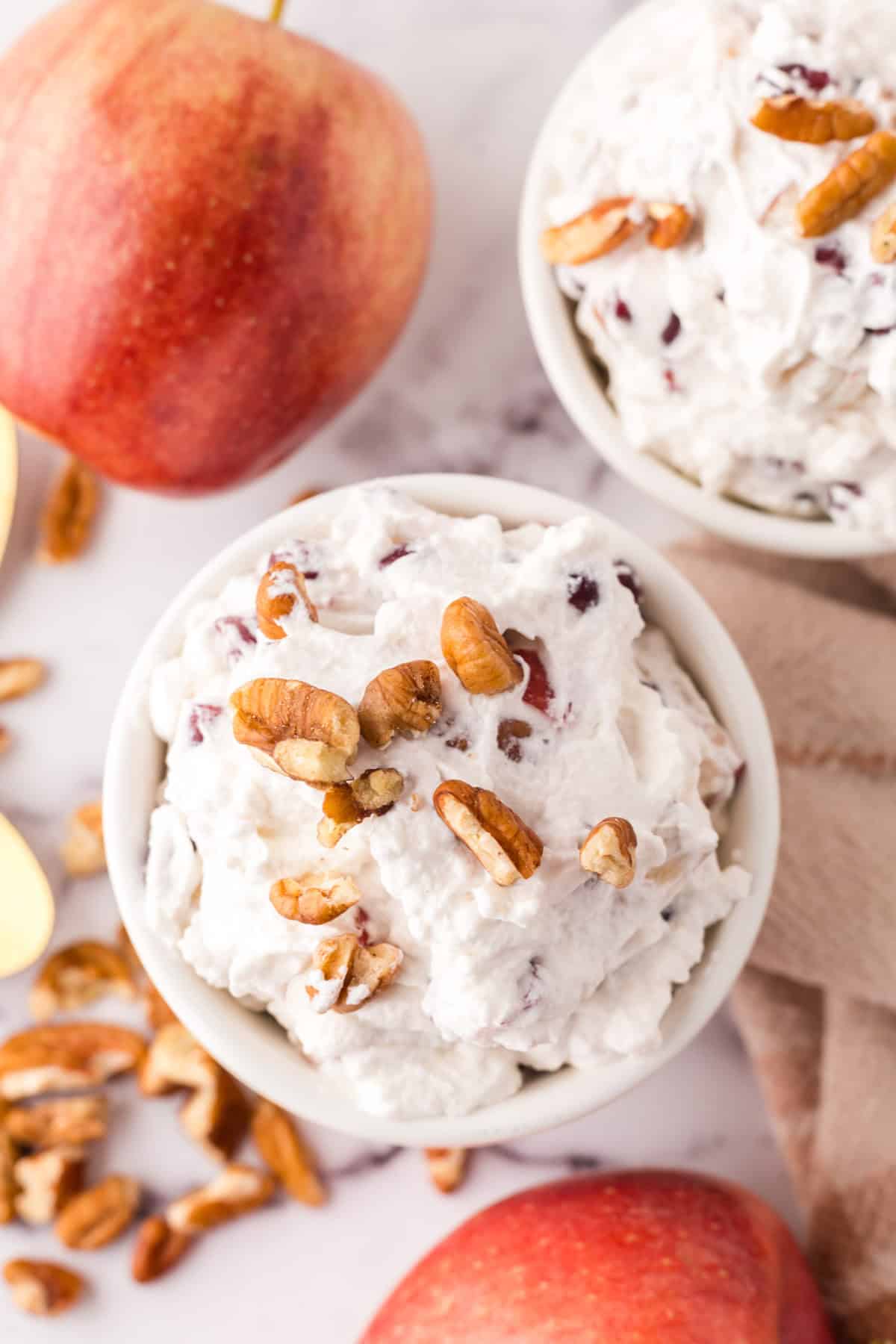 small white portion bowl with dixie salad recipe and walnuts on top.