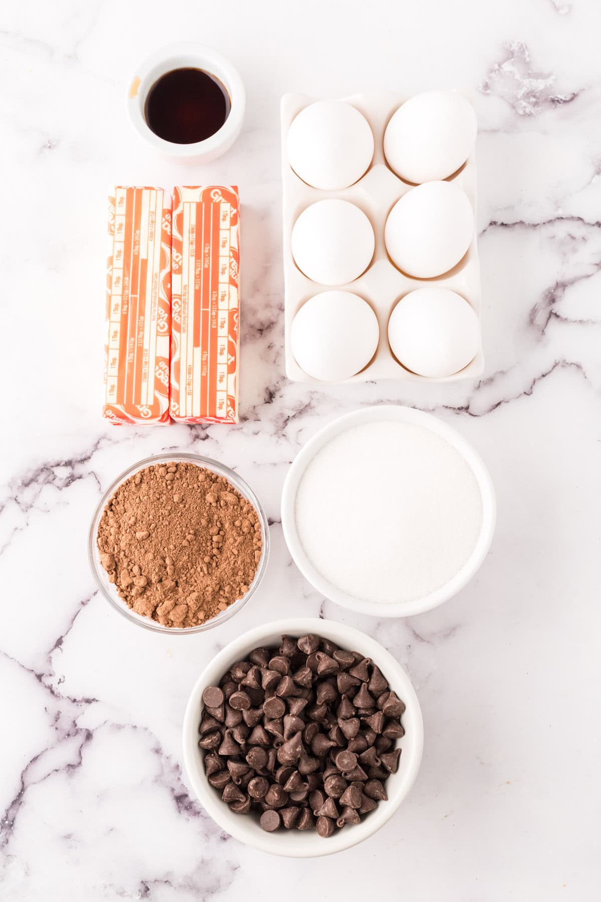 portion bowls each with raw ingredients to make the flourless chocolate cake recipe.