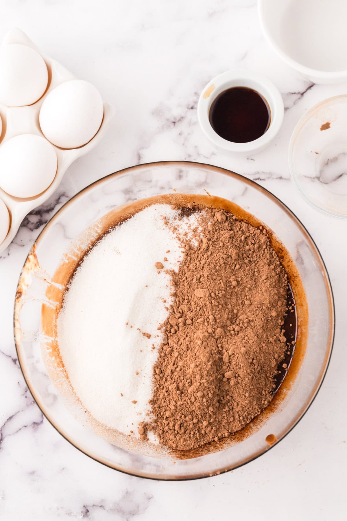 clear mixing bowl in the process of making flourless chocolate cake batter.
