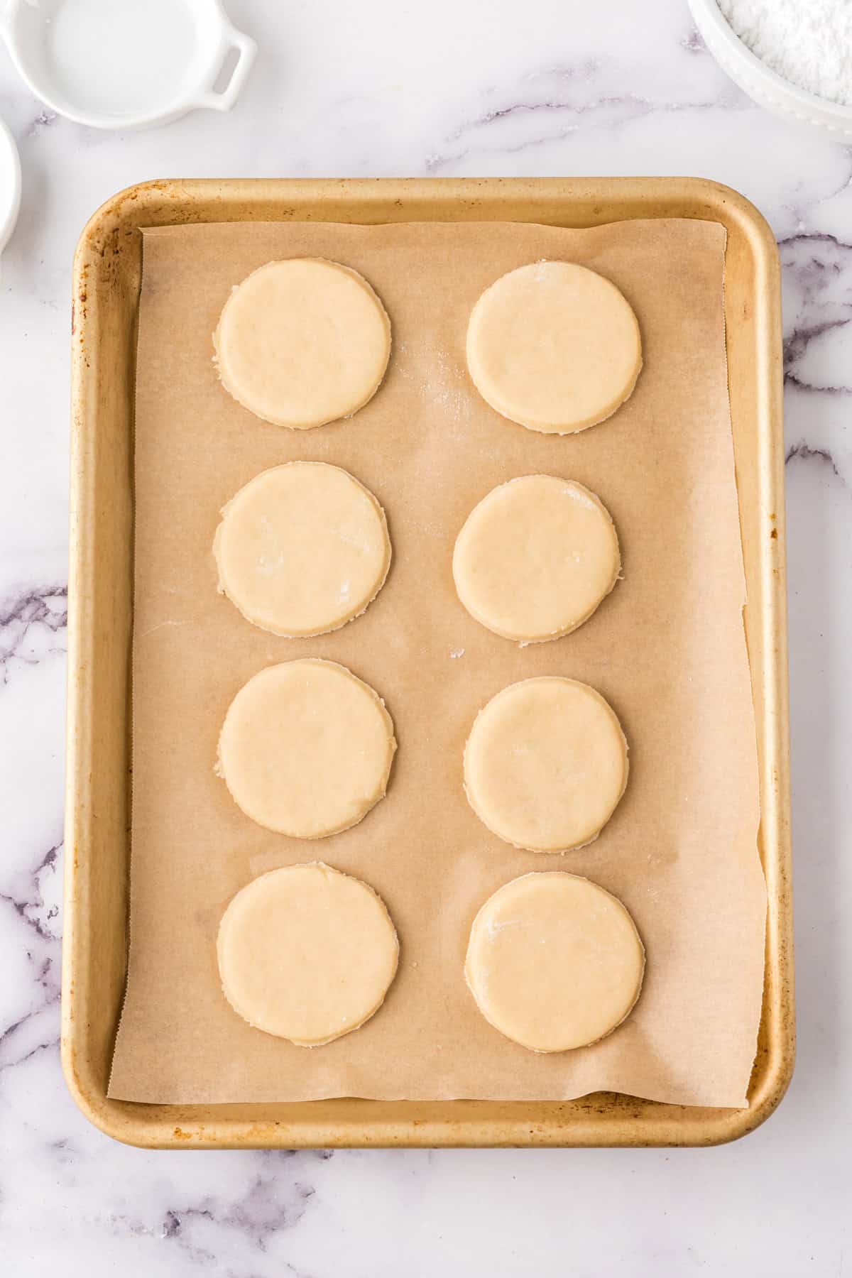 raw dough for fruit pizza cookies on parchment on a half sheet pan before being baked and topped.