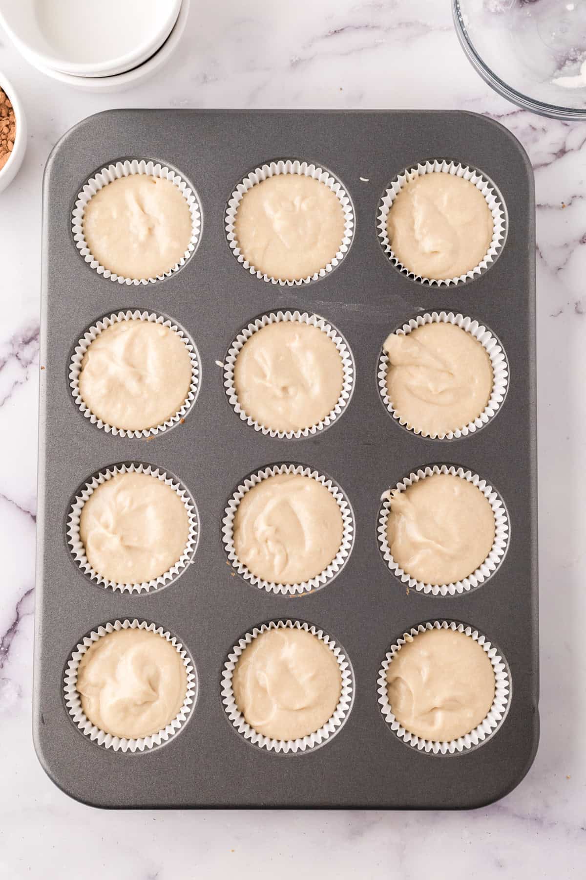 cupcake tin with vanilla cupcake batter in and ready to bake.