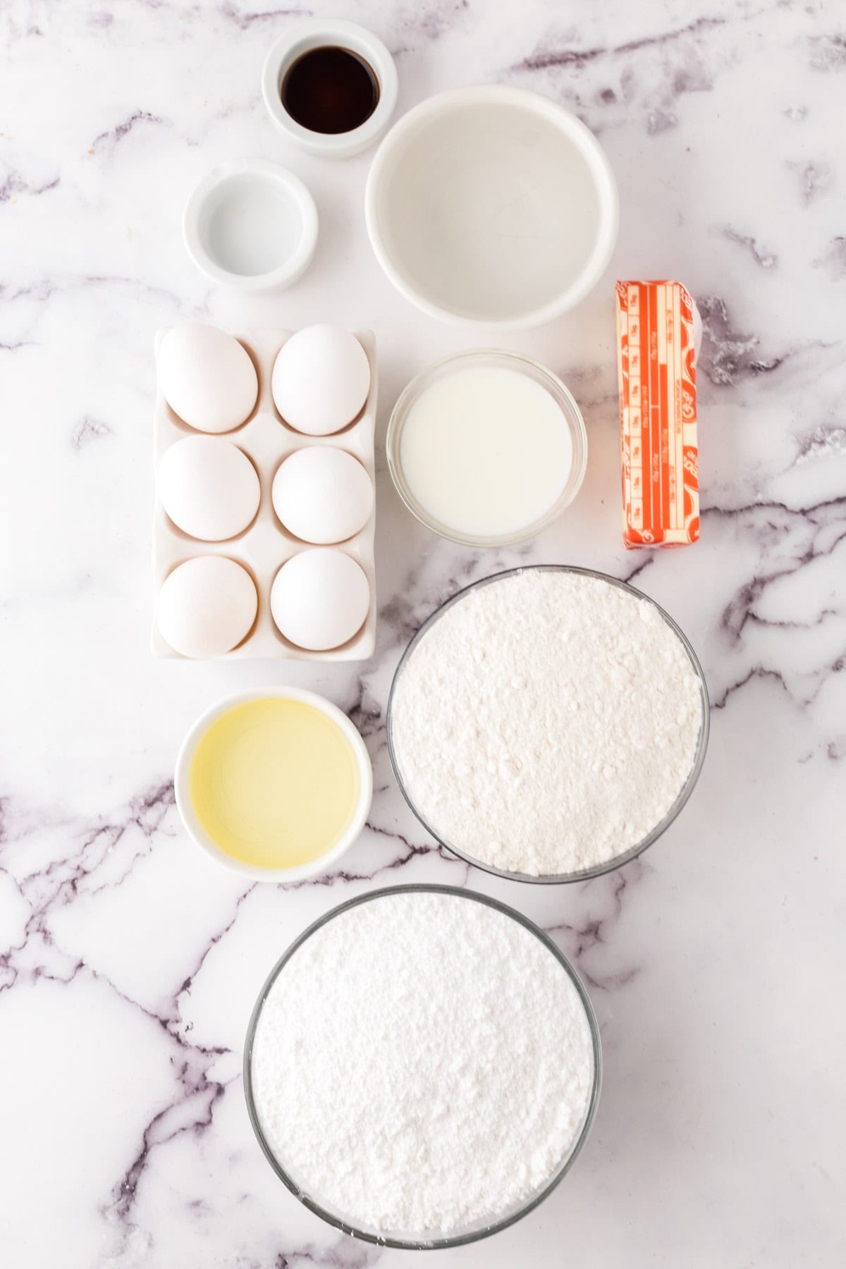 portion bowls each with raw ingredients to make vanilla sheet cake recipe.