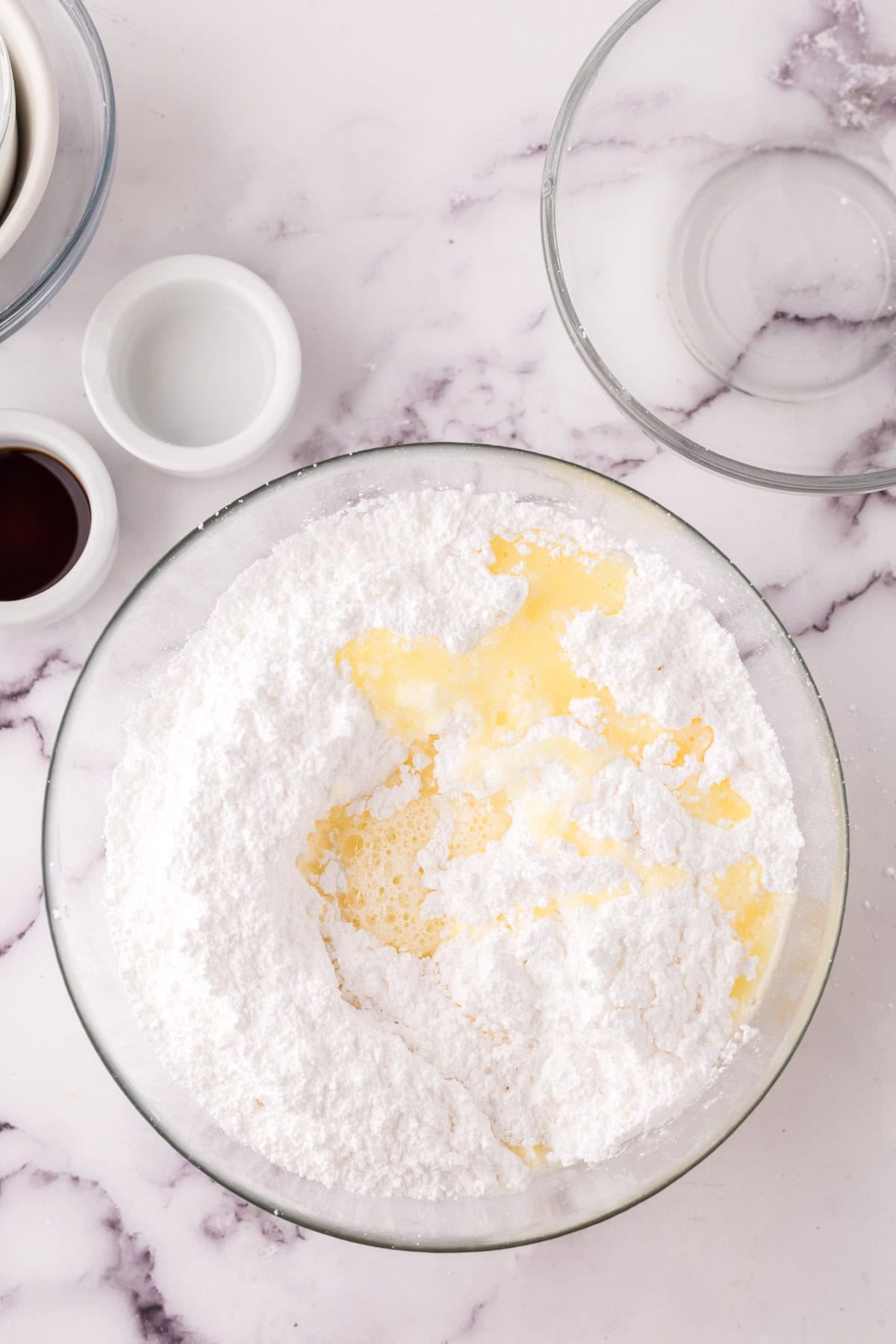 clear mixing bowl with the progress of making the vanilla sheet cake recipe.