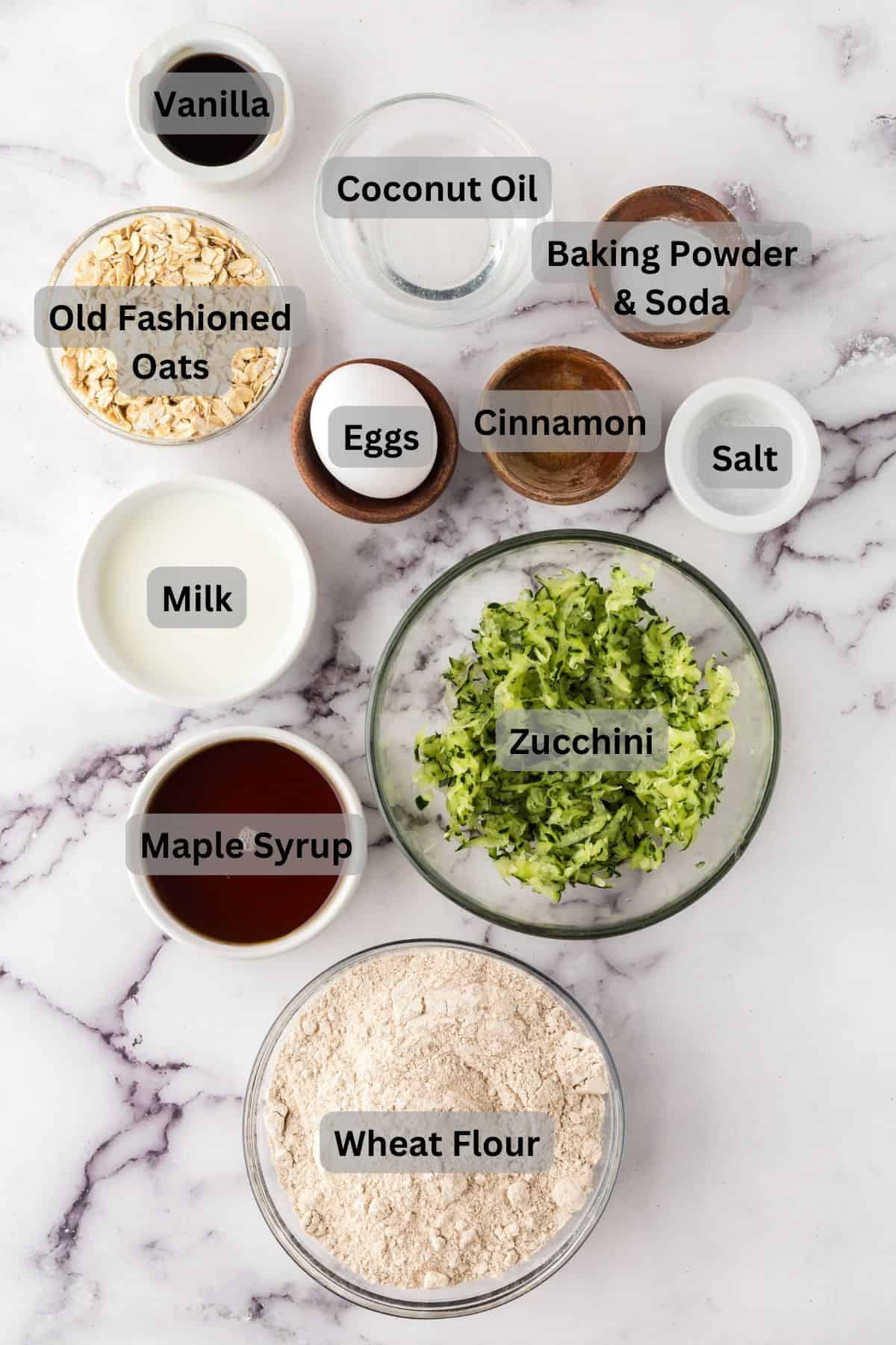 portion bowls each with digitally labeled raw ingredients to make whole grain zucchini muffins.