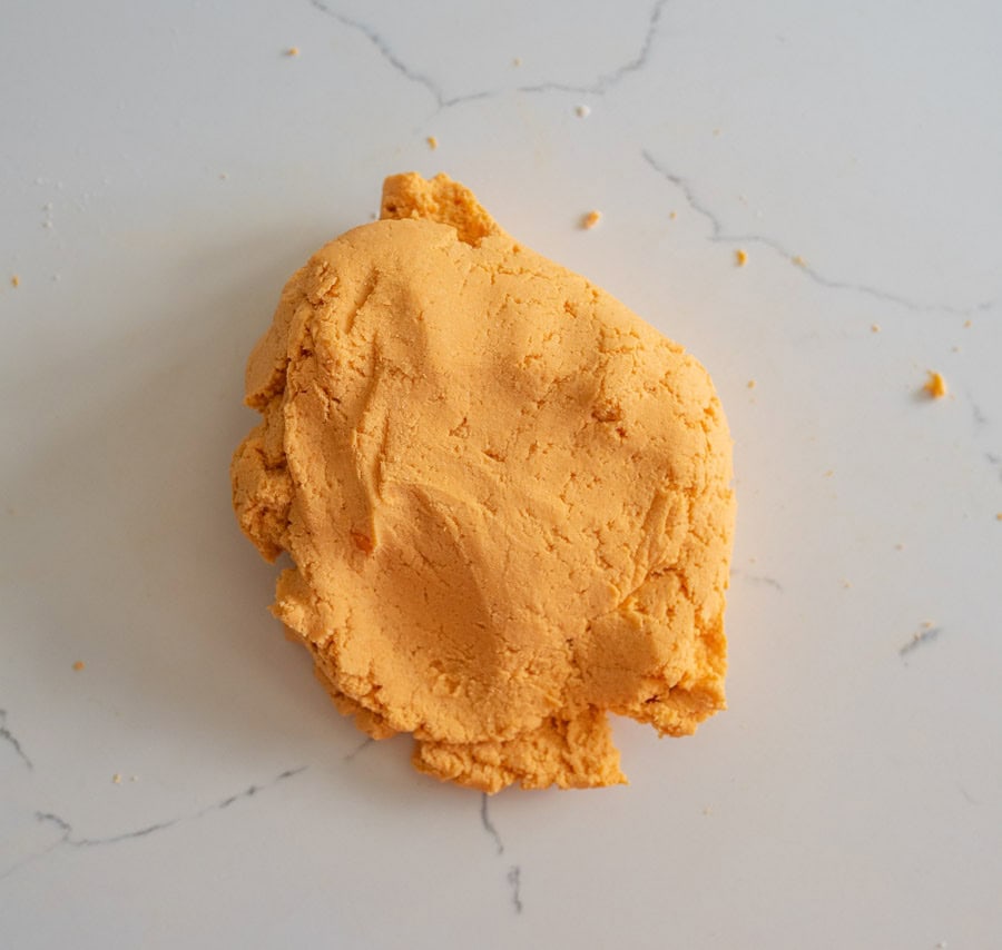 Cassava flour and sweet potato tortilla dough on a white marble counter.