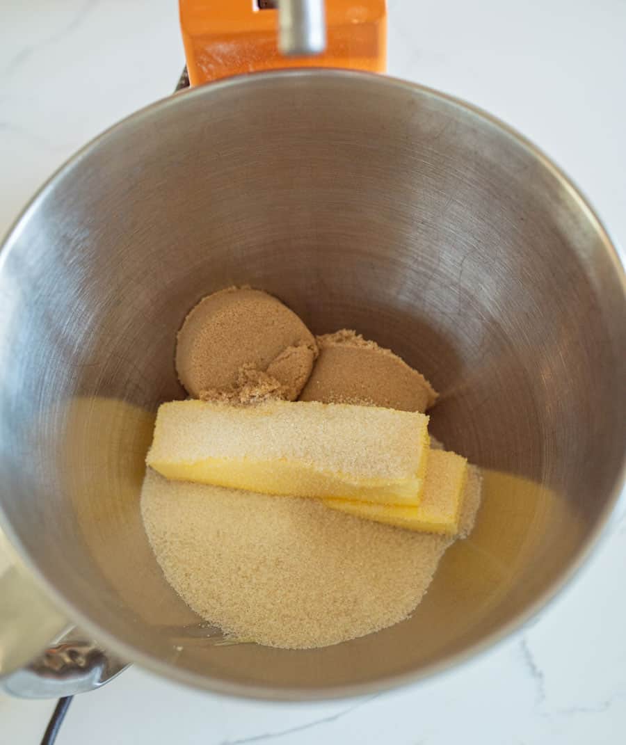 Butter and sugars for dark chocolate Halloween M&M Cookie dough in a mixing bowl.