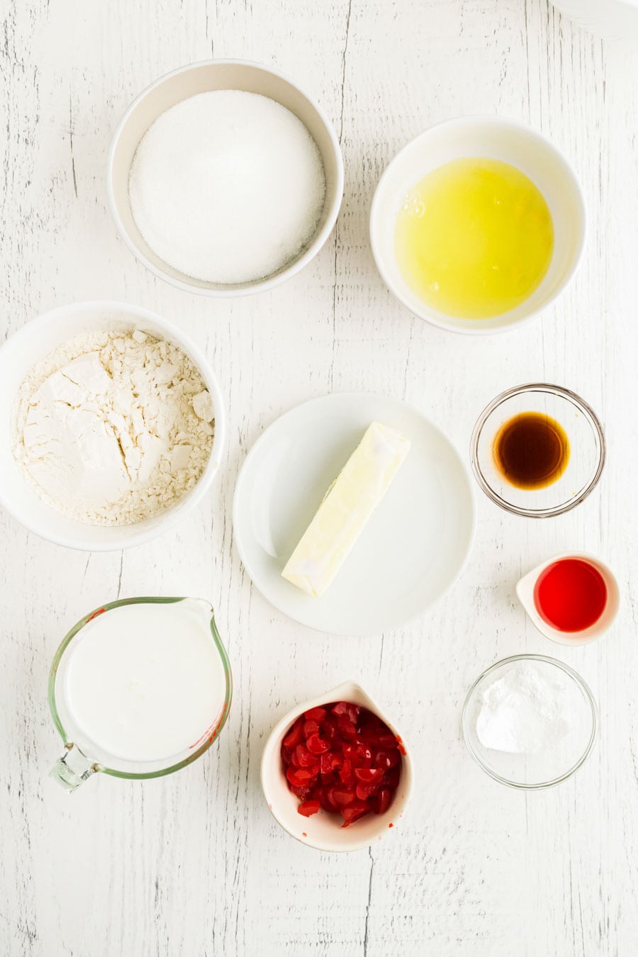 All of the ingredients for cherry chip cupcakes on a white background.