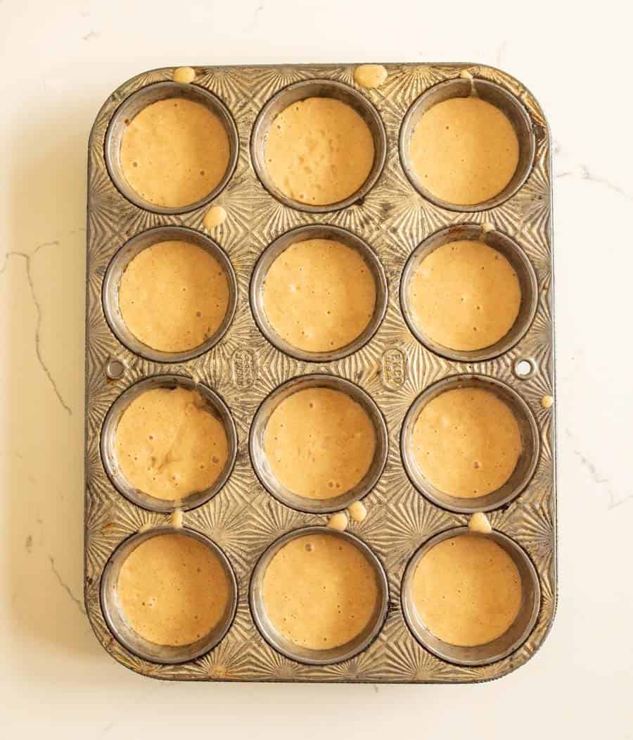 Sourdough muffin batter poured into a muffin pan before baking.