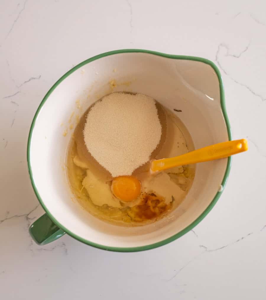 Some of the ingredients before they are stirred in a white bowl with a green rim on a white counter.