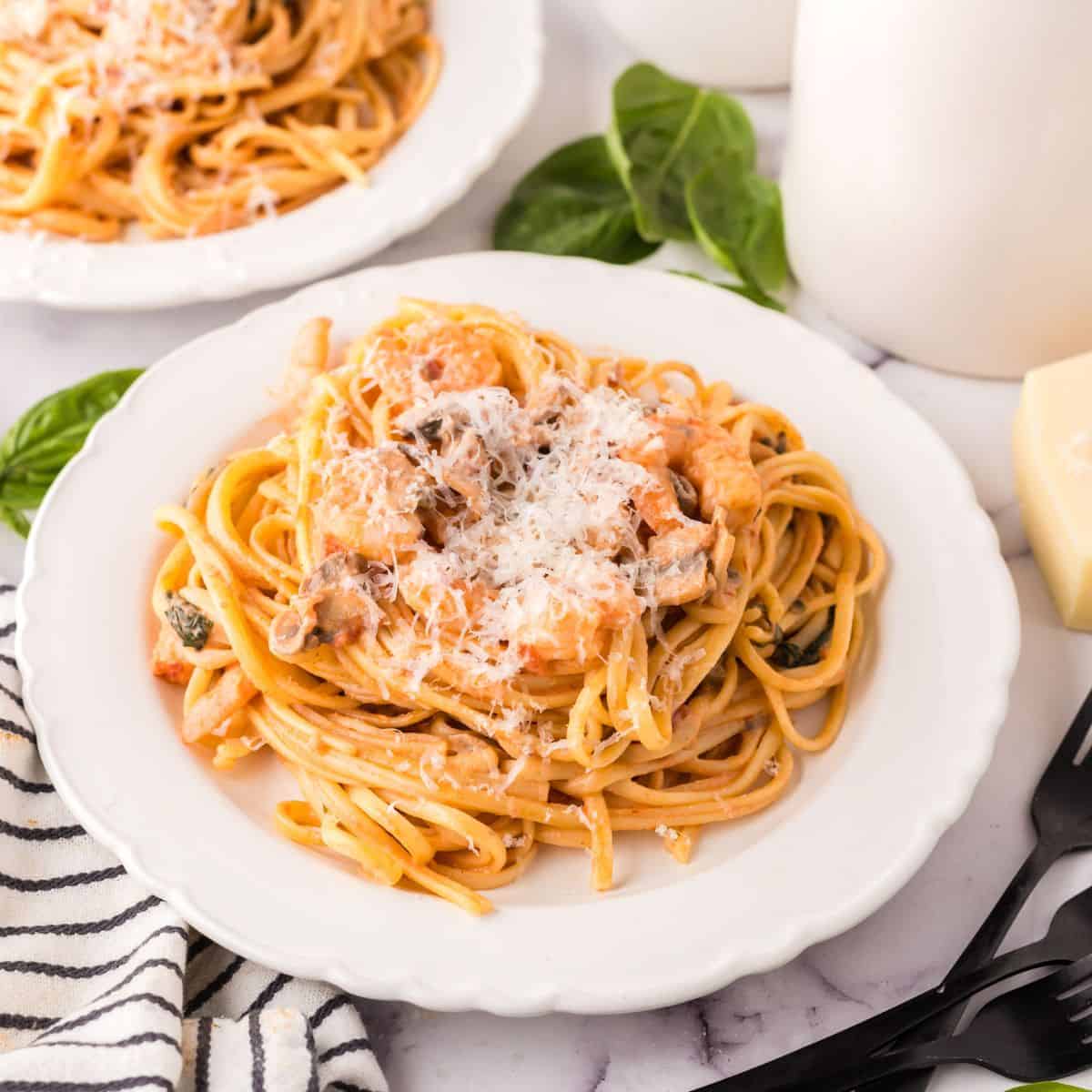 linguine rosa with shrimp on a round plate.
