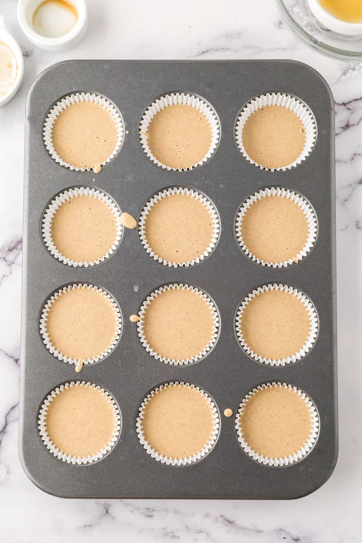 muffin tin filled with muffin batter.