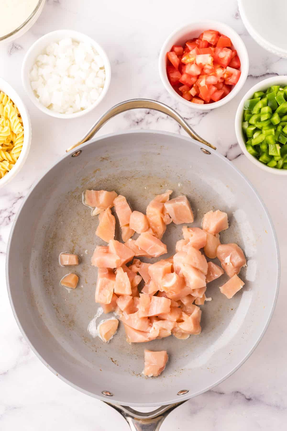 sautéed pan in the process of making creamy chicken bacon pasta.