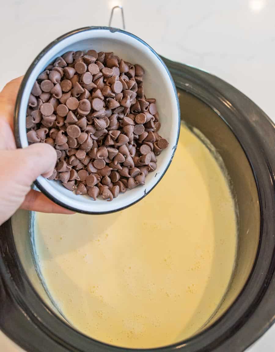 The cream, milk, and sweetened condensed milk in the crock pot before the chocolate chips are added.
