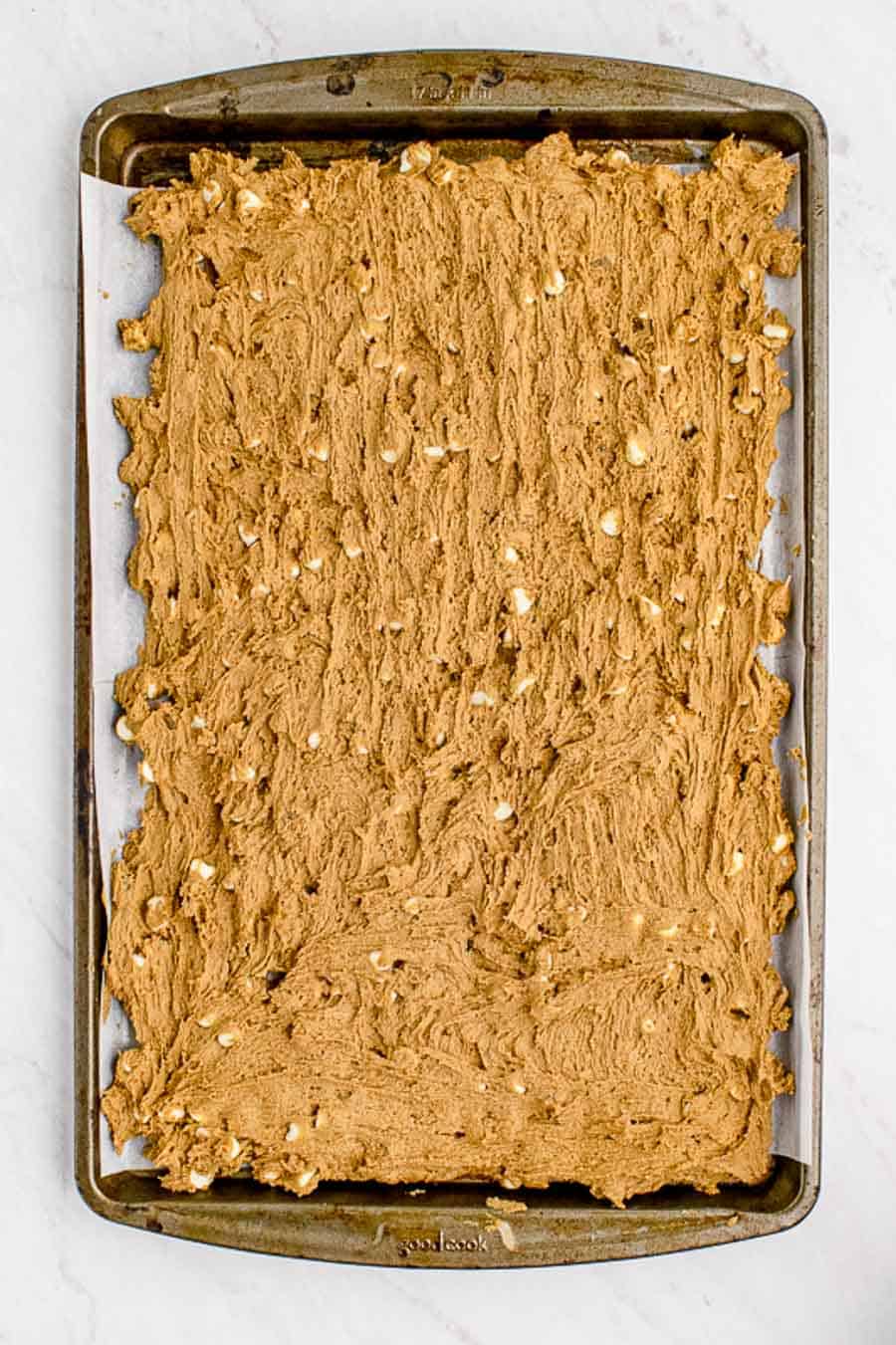 Raw gingerbread blondie batter in the baking sheet before baking.
