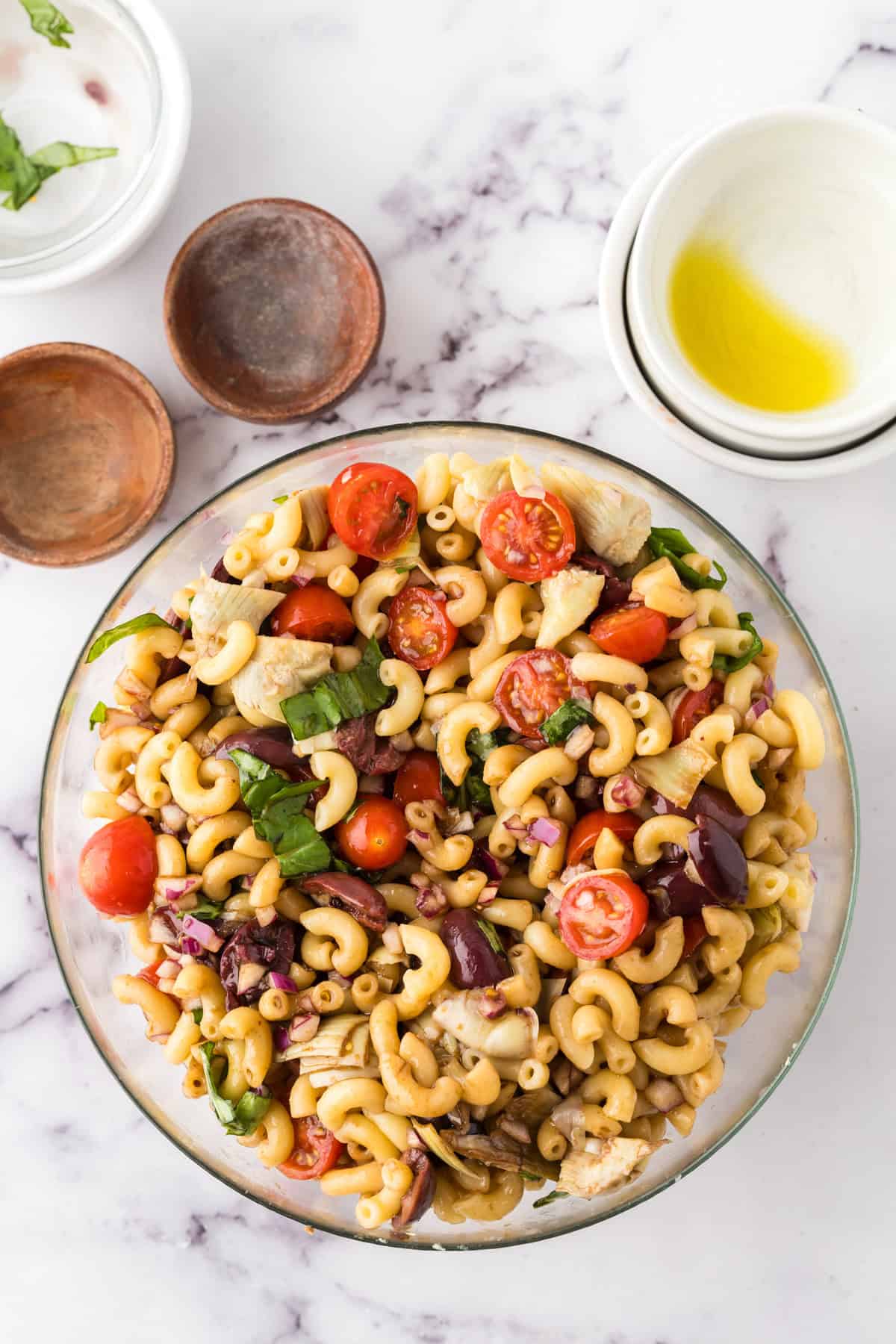 clear mixing bowl in the process of making Italian Pasta Salad.