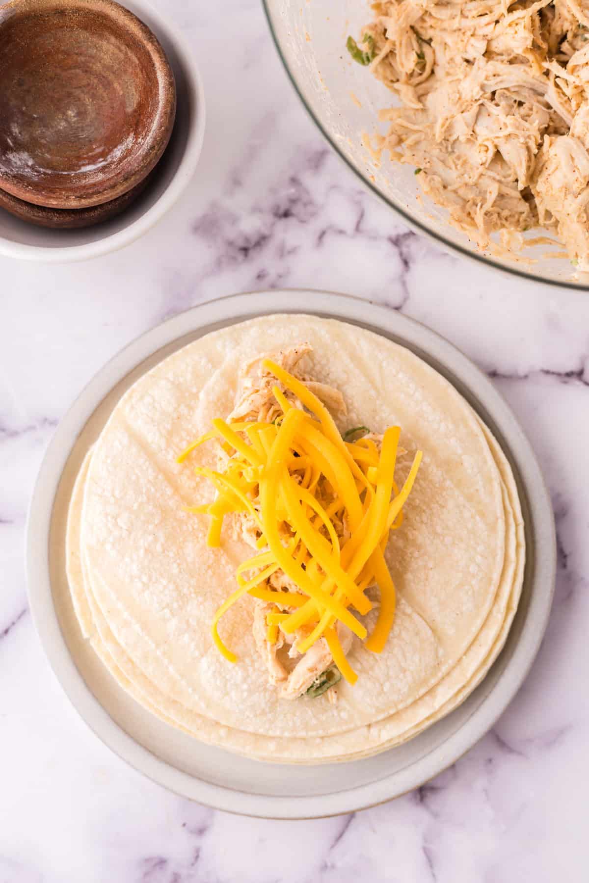 Filling a tortilla with cheese and turkey mixture.