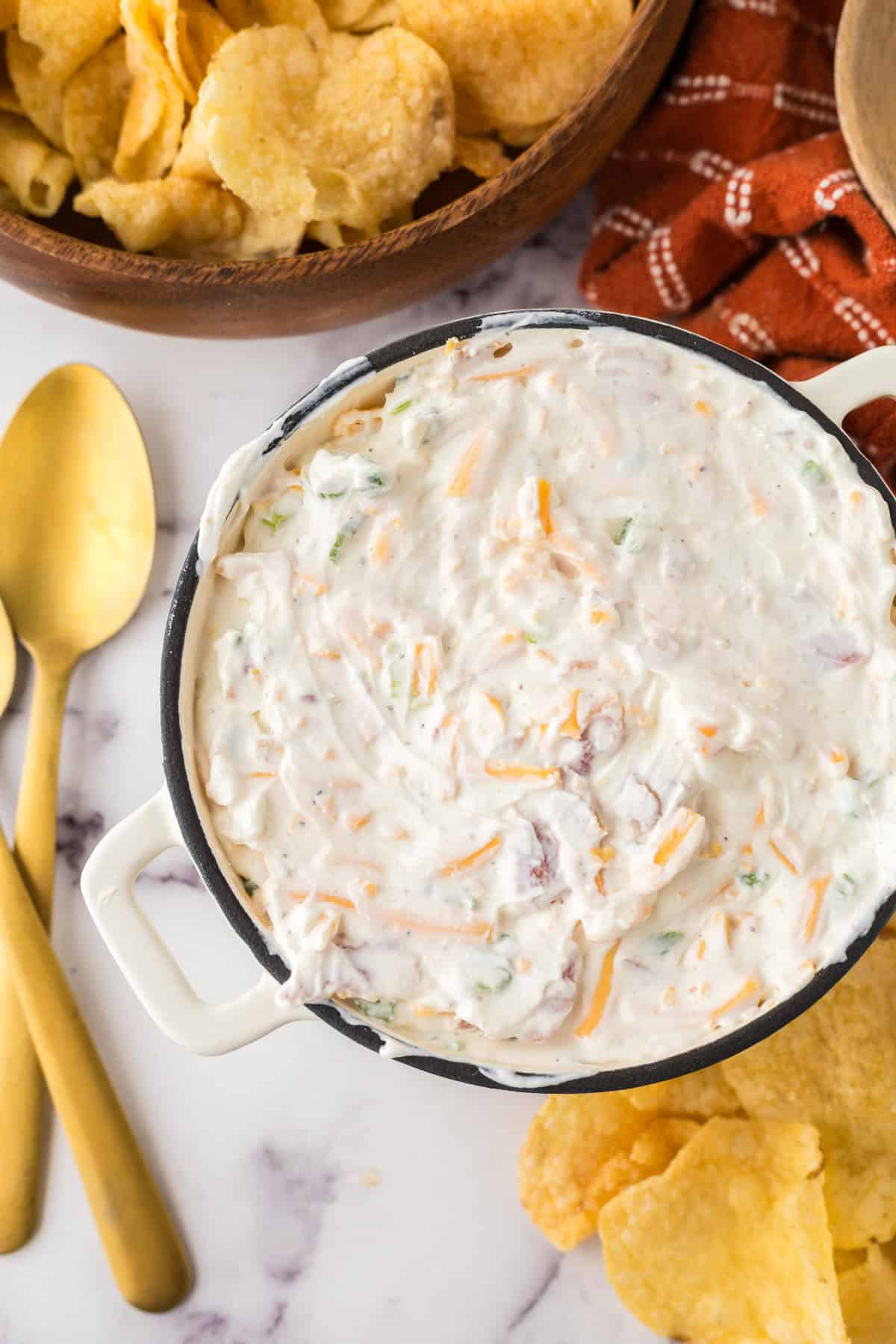loaded baked potato dip in a bowl with potato chips.