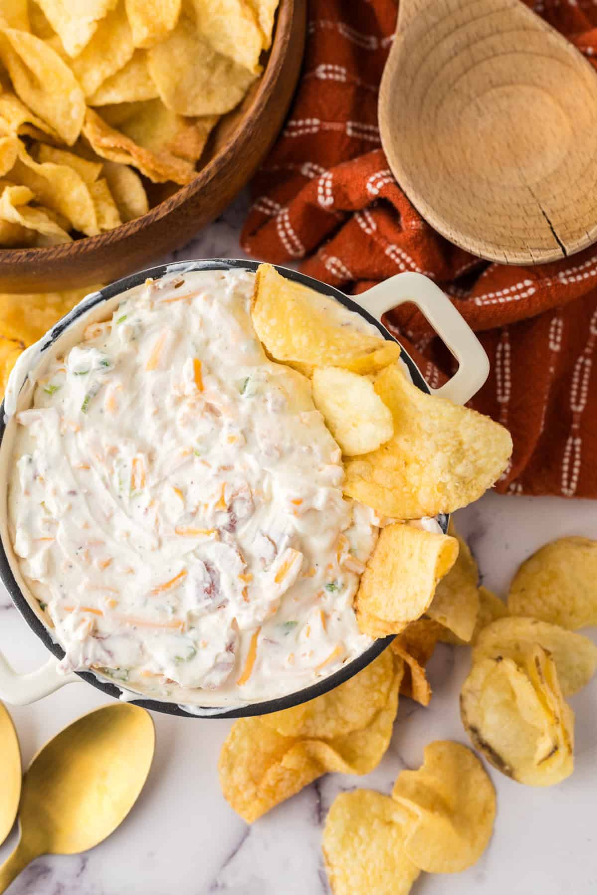 loaded baked potato dip in a bowl with potato chips.